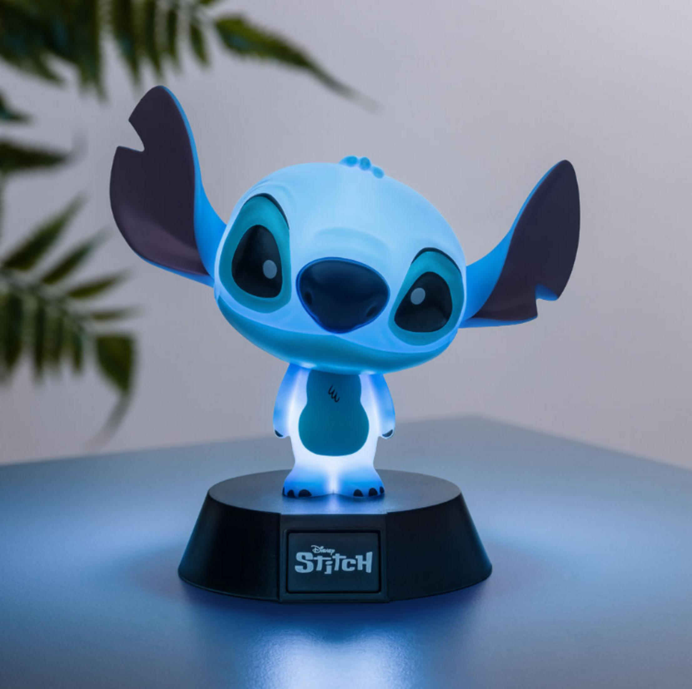 Eine leuchtende Stitch-Figur mit großen Ohren steht auf einem schwarzen Sockel.
