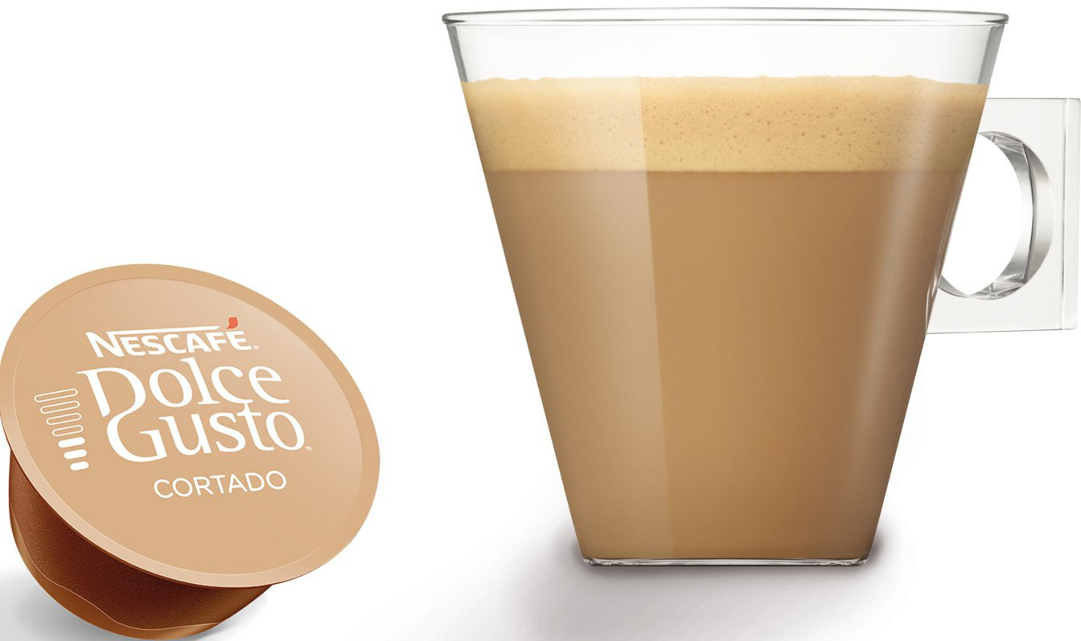 Eine Nescafé Dolce Gusto Cortado Kapsel neben einem Glas Cortado-Kaffee.