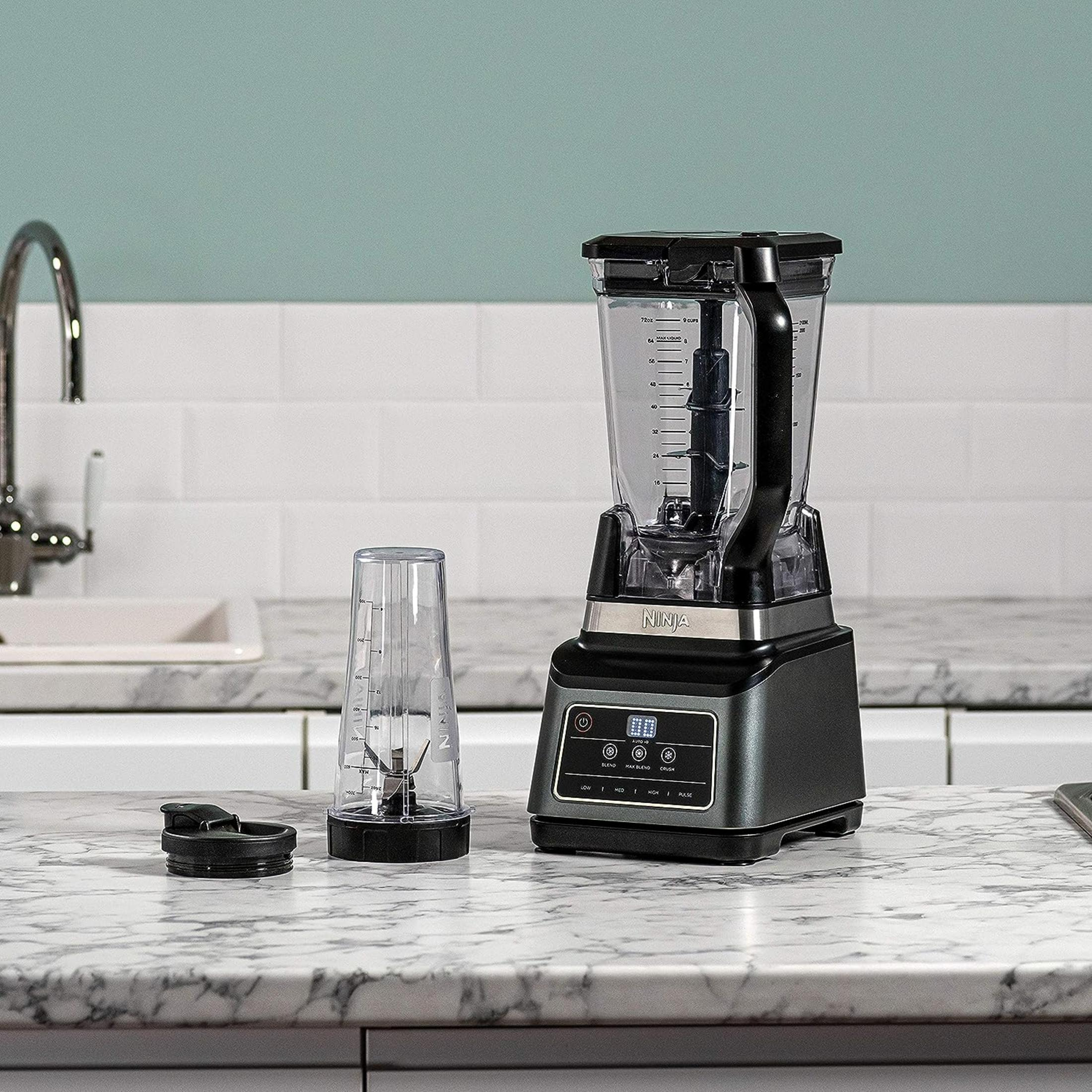 Blender Ninja z kubkiem i pokrywką na marmurowym blacie.