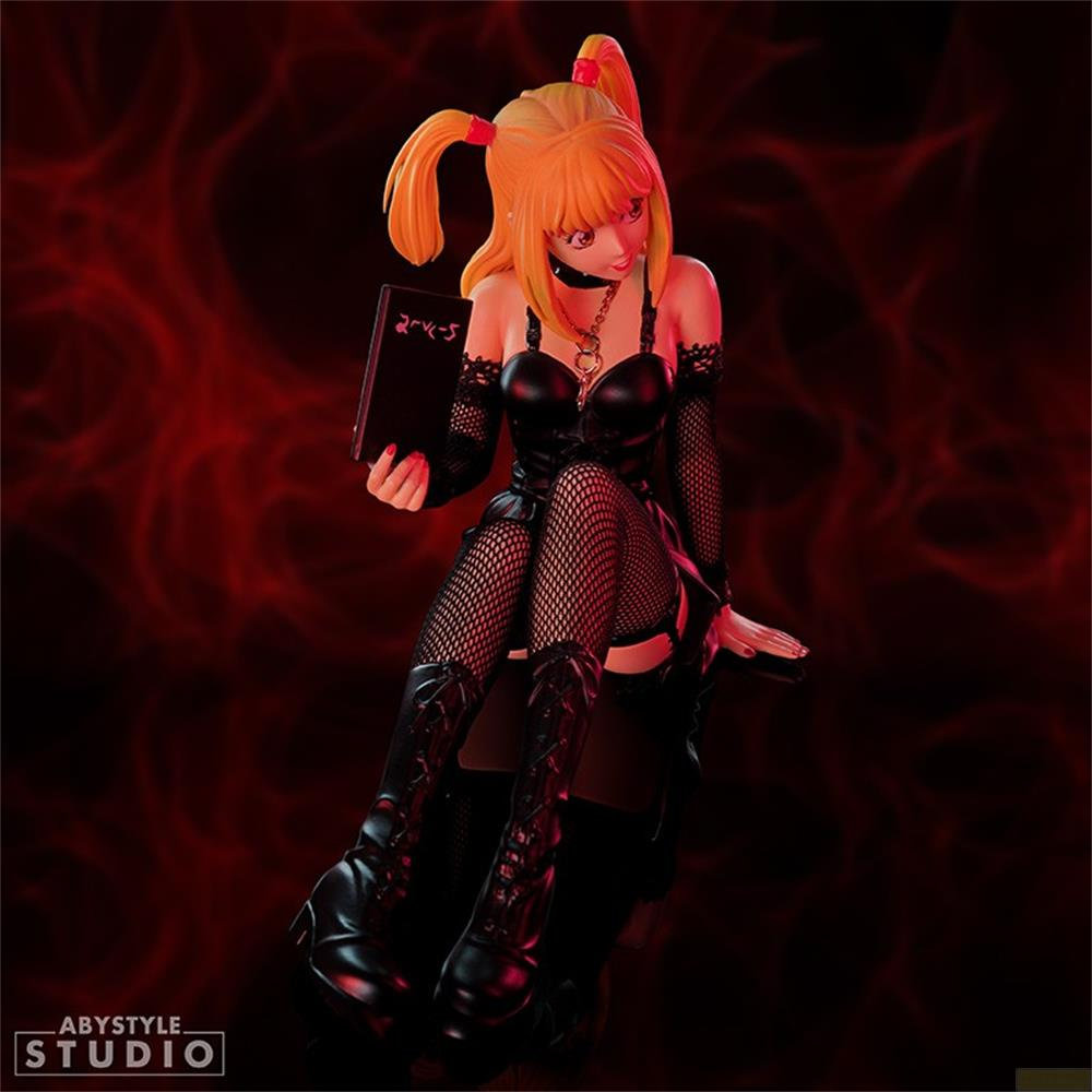 Anime-Figur mit orangefarbenem Haar, hält ein Buch, trägt schwarze Kleidung.