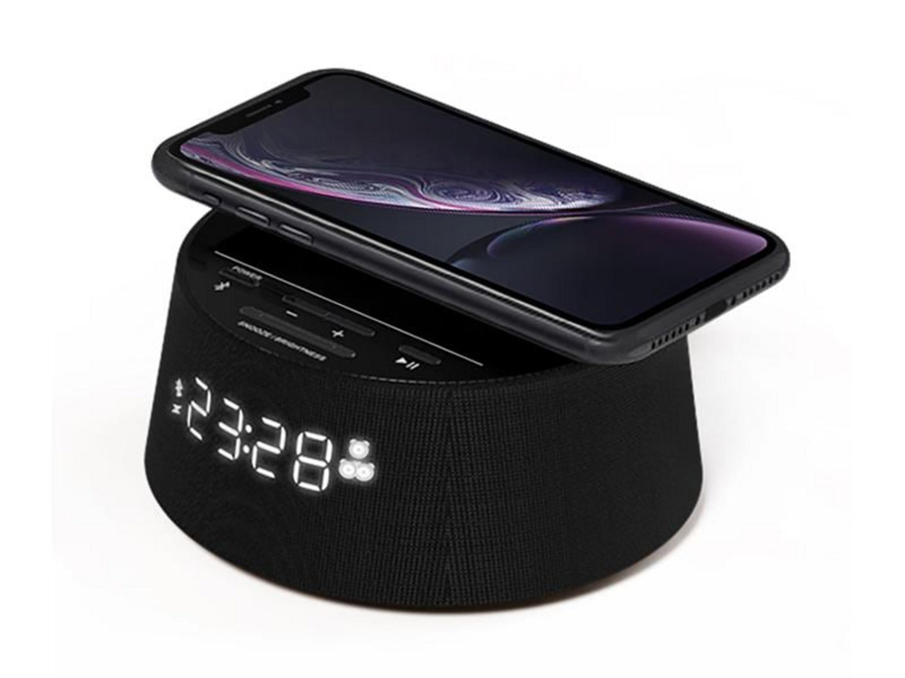 Un altoparlante nero con orologio digitale e smartphone sopra.