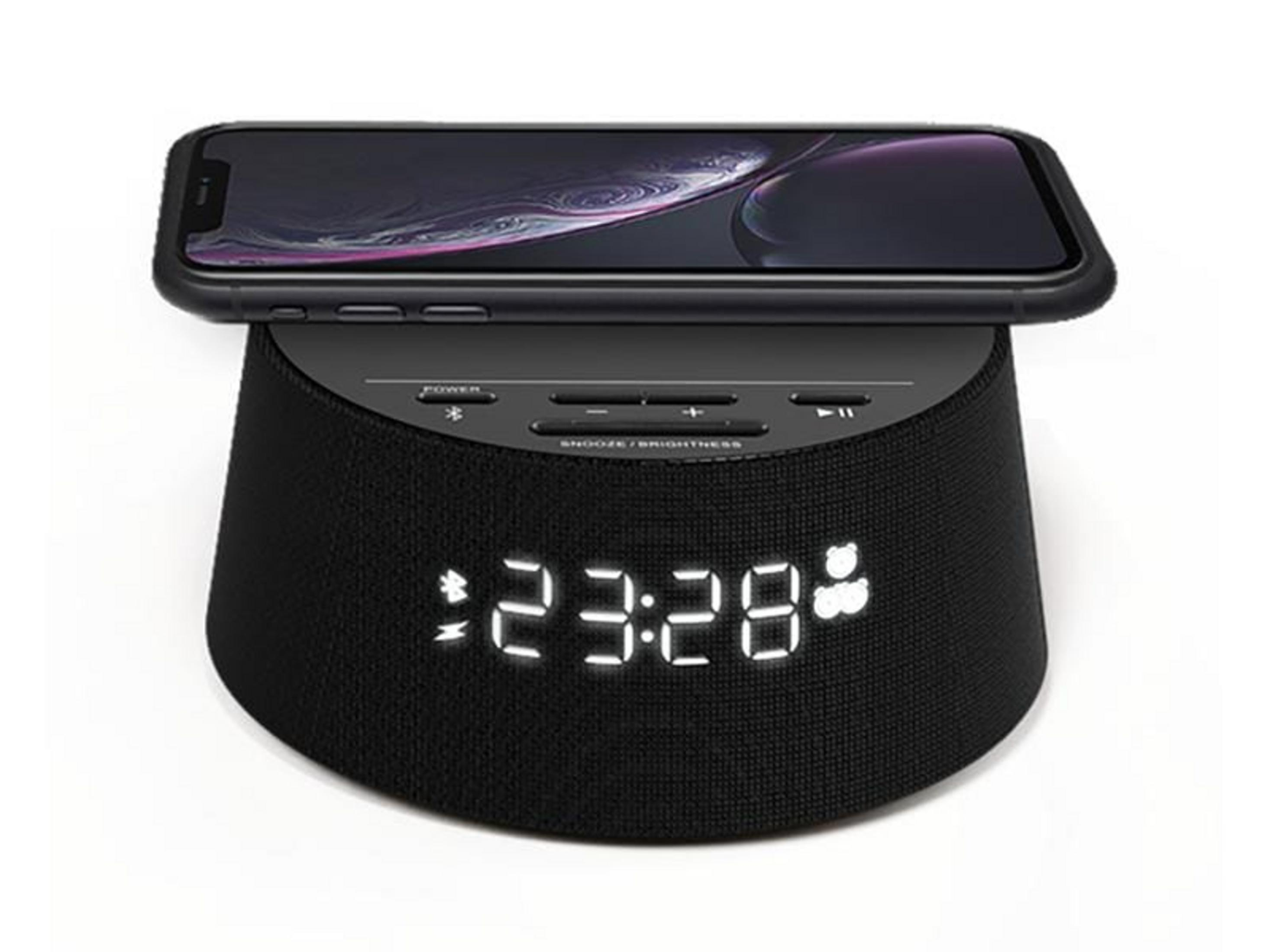 Un altoparlante nero con orologio digitale (23:28) e un telefono sopra.