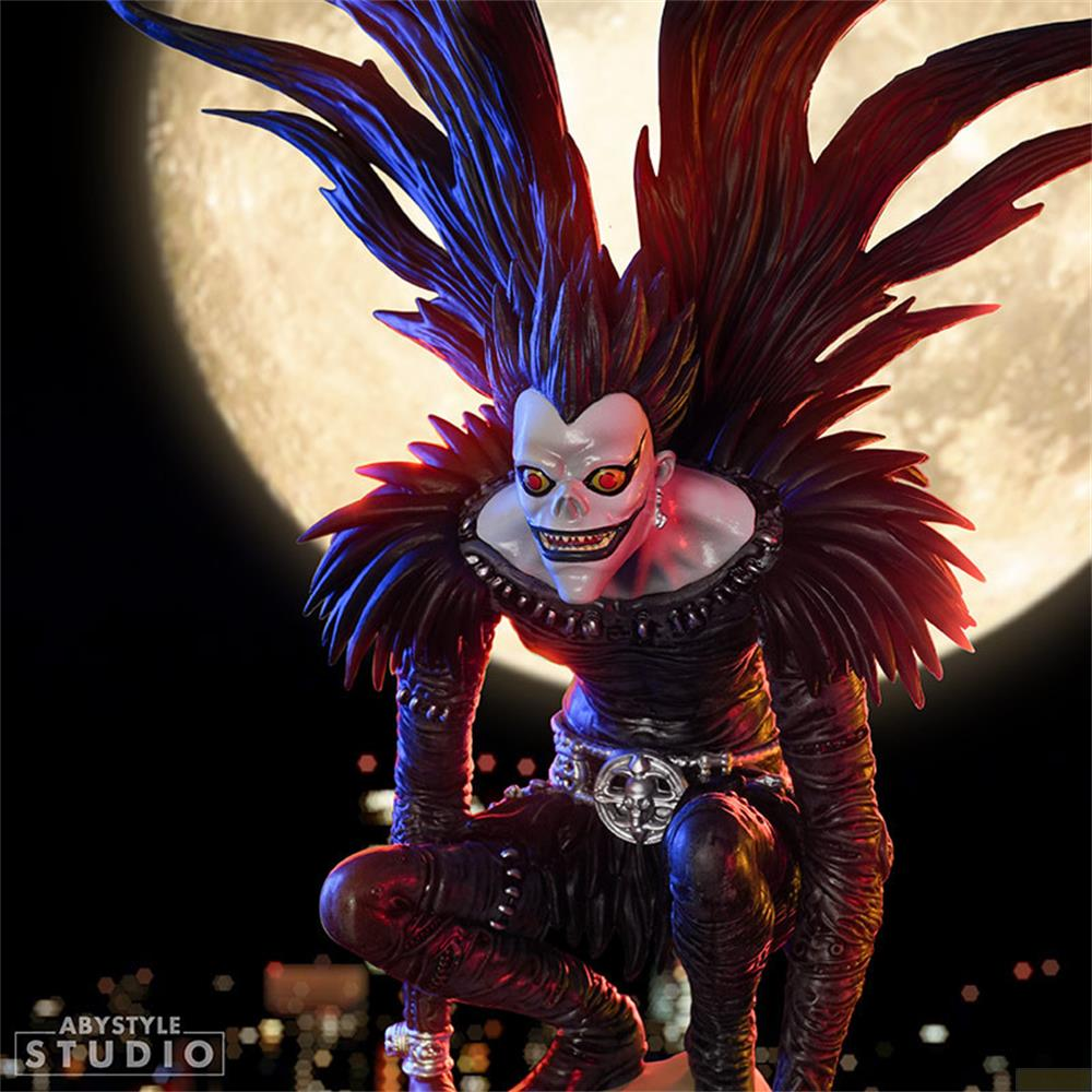 Eine Figur mit schwarzen Haaren und dunkler Kleidung kauert vor einem Mond.