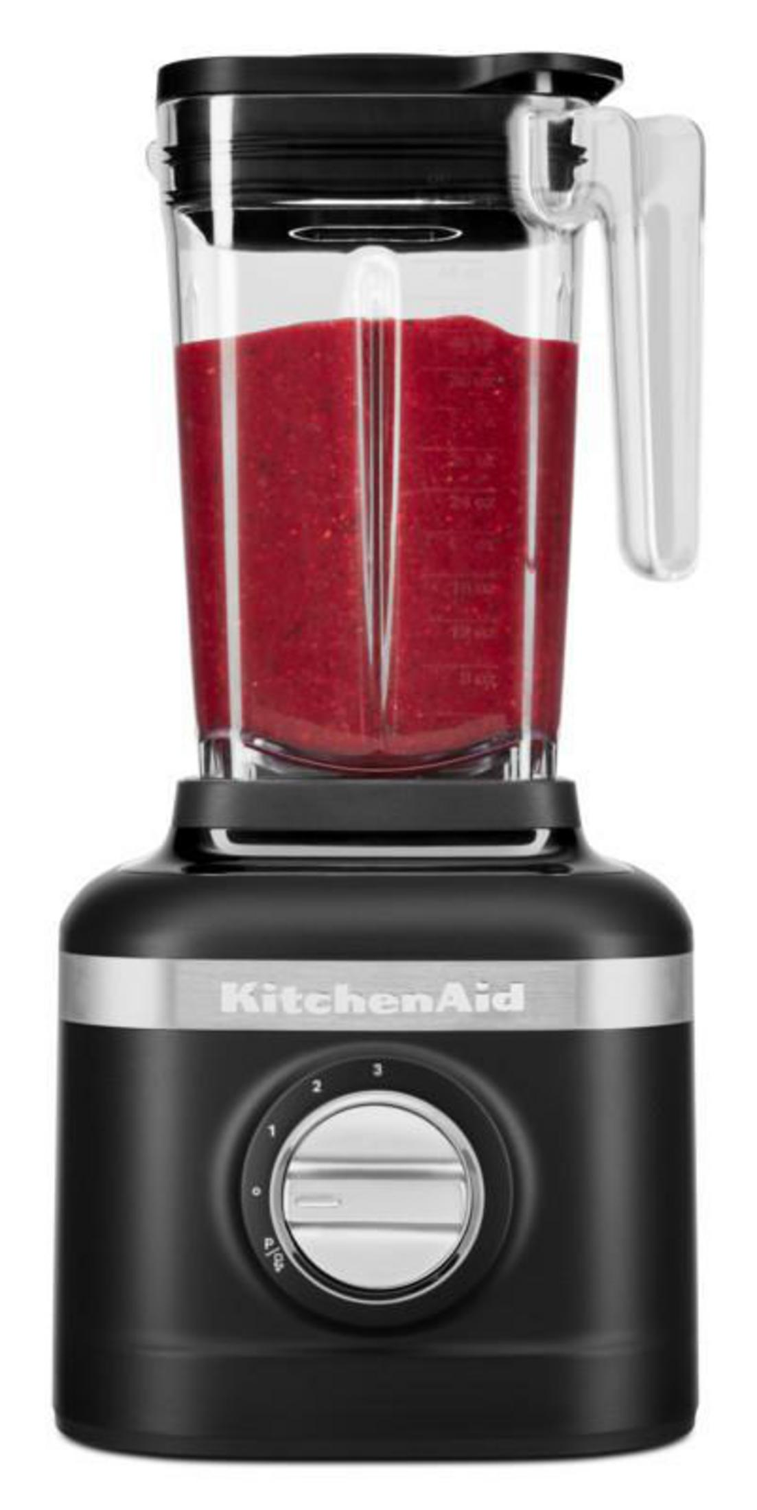 Schwarzer Standmixer mit rotem Smoothie und silbernem Drehknopf.