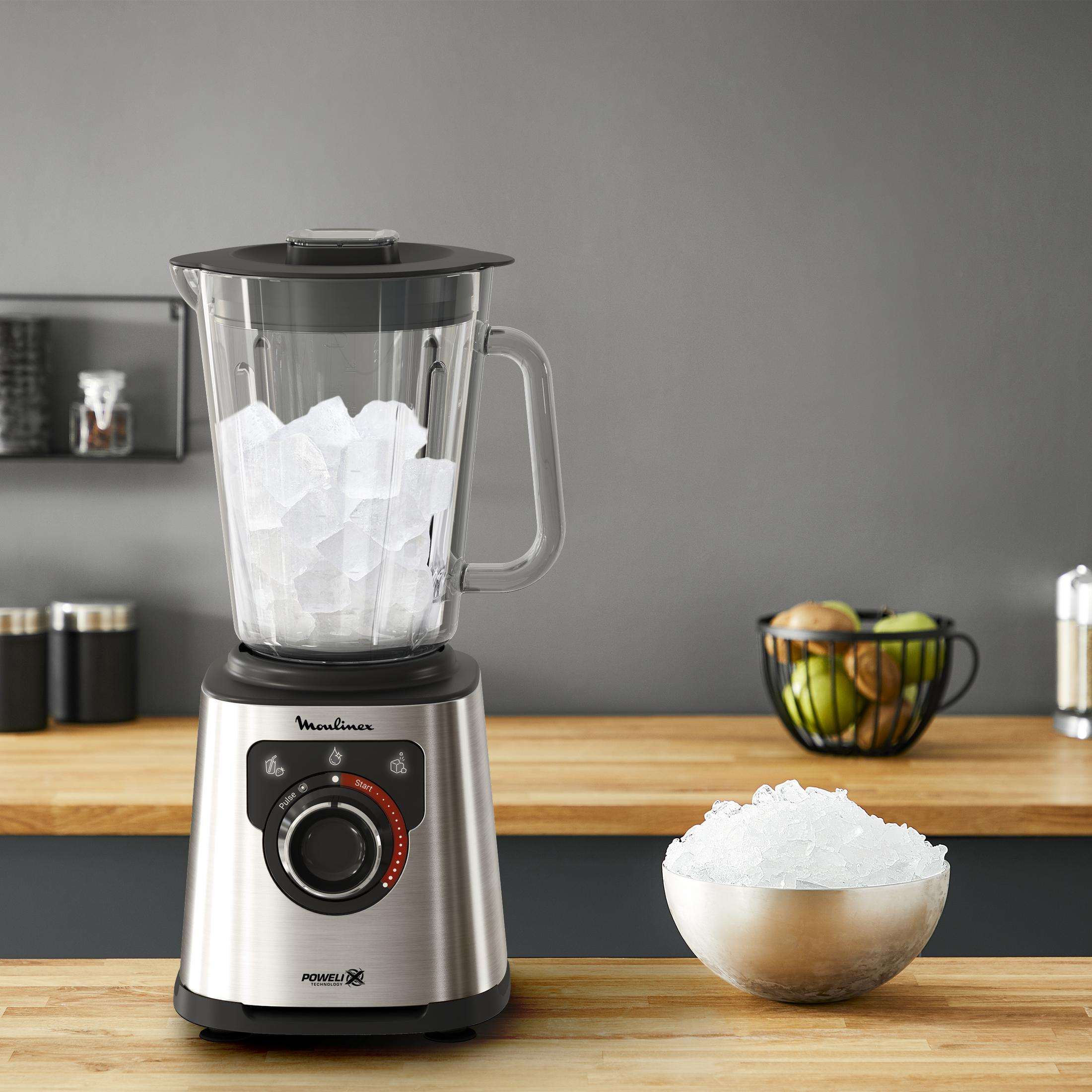 Ein Mixer mit Eiswürfeln im Glasbehälter und in einer Schale.