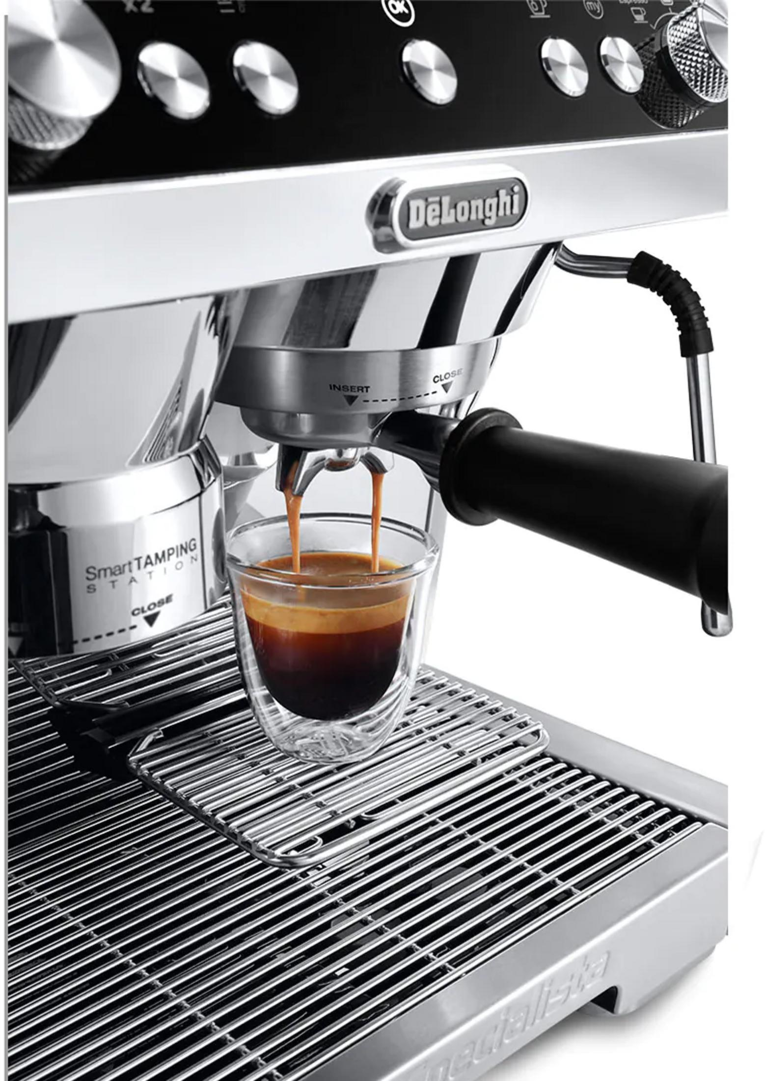 Eine Kaffeemaschine brüht Espresso in ein Glas, mit DeLonghi-Logo.