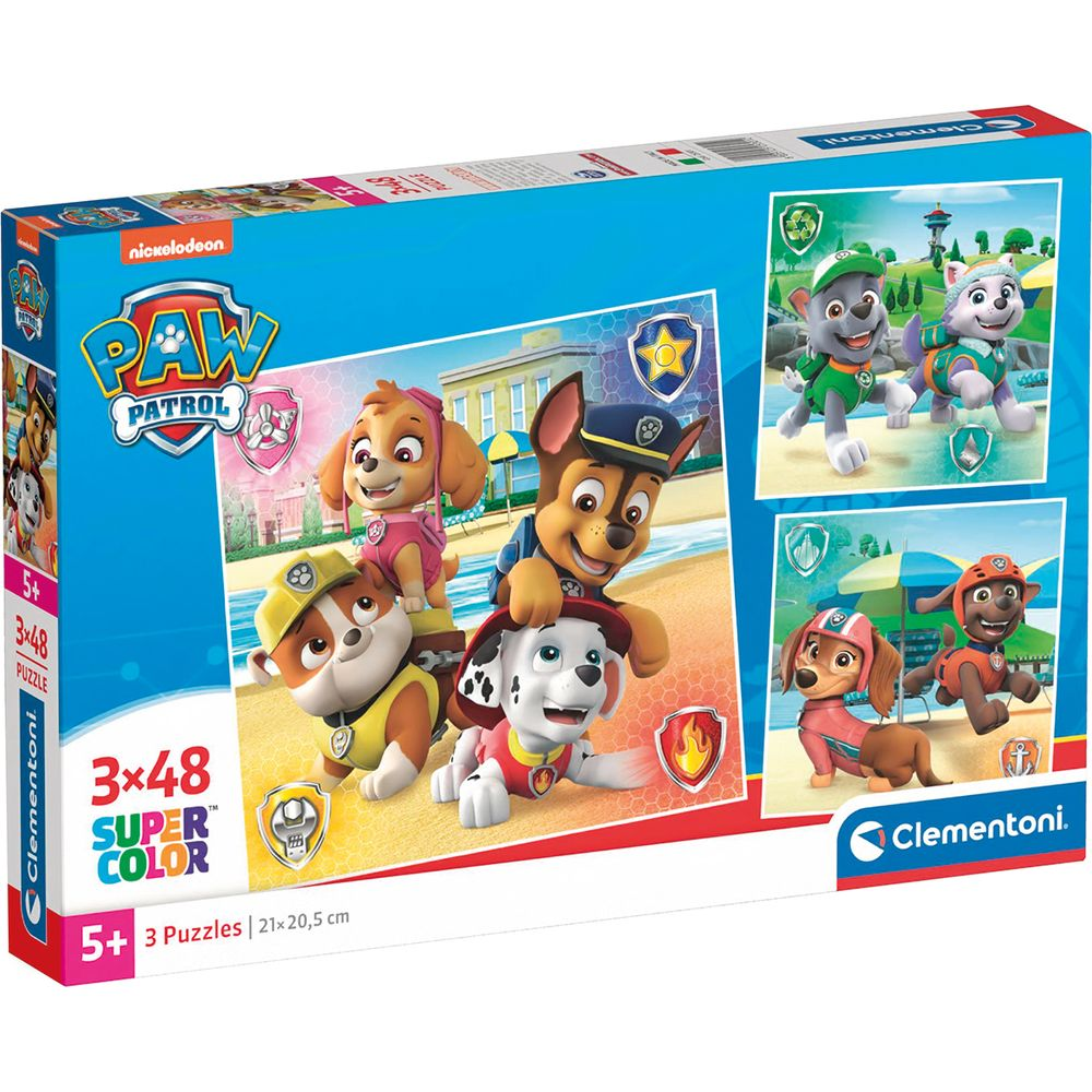Pudełko puzzli Paw Patrol z czterema psami na plaży i trawie.