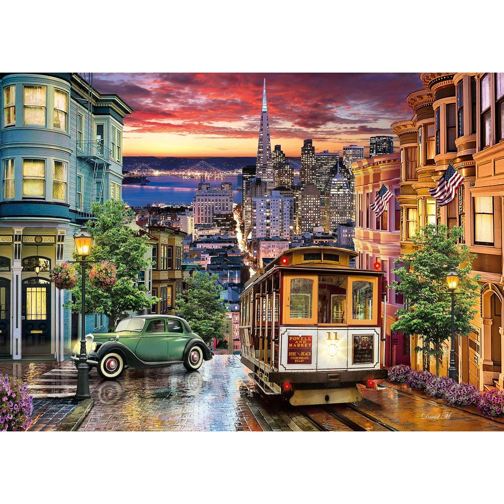 Tramwaj w San Francisco o zachodzie słońca z wieżowcami i wiktoriańskimi domami.
