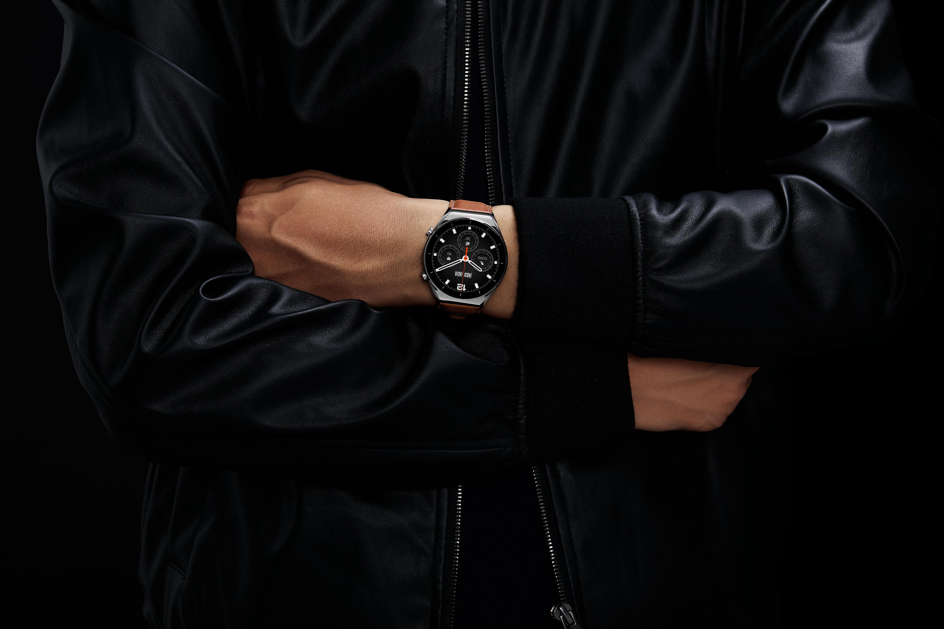 Una persona lleva una chaqueta de cuero negra y un reloj inteligente marrón.