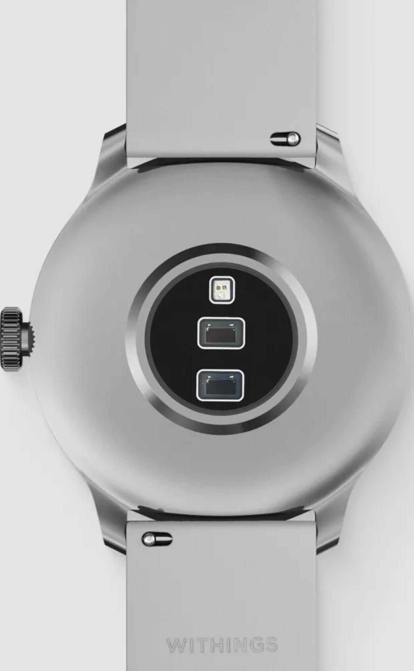 Tył srebrnego smartwatcha z teksturowaną koronką i pinami ładującymi.