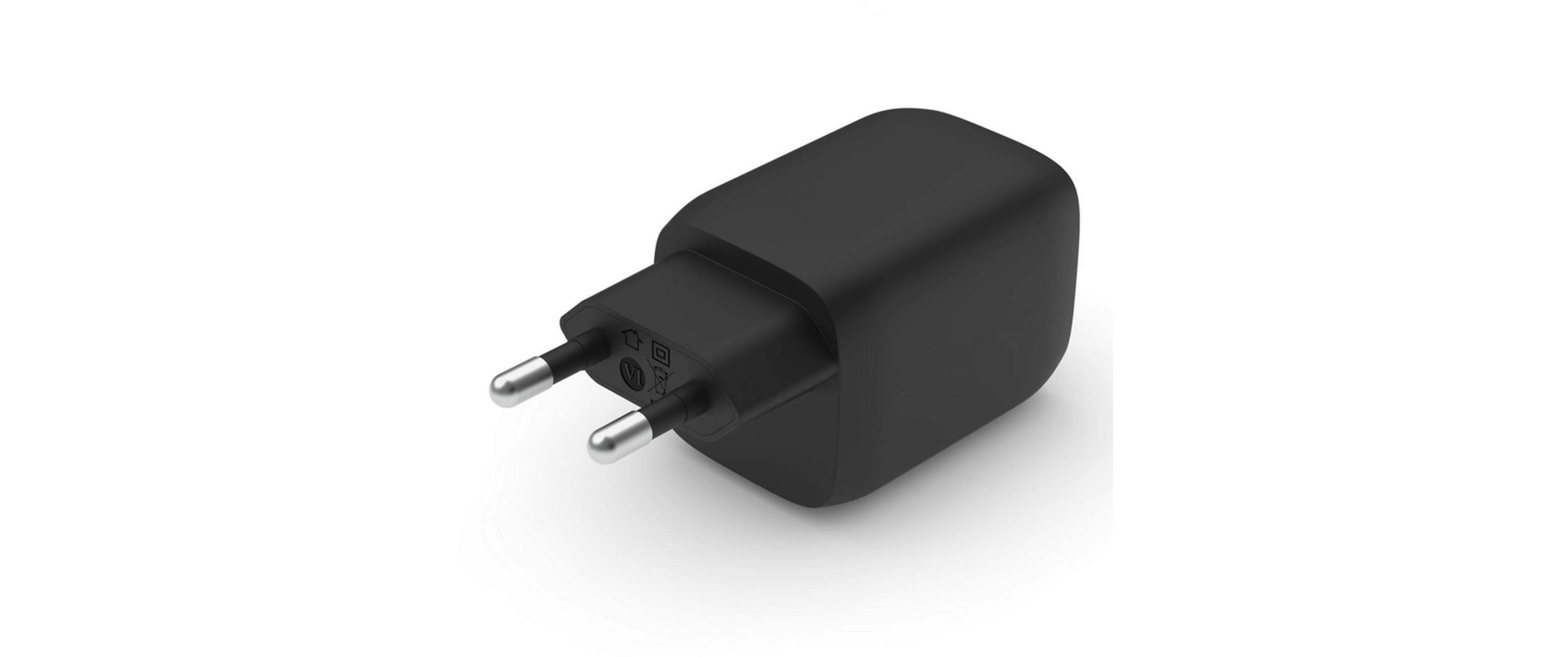 Un adaptador de corriente negro con dos clavijas plateadas y símbolos.
