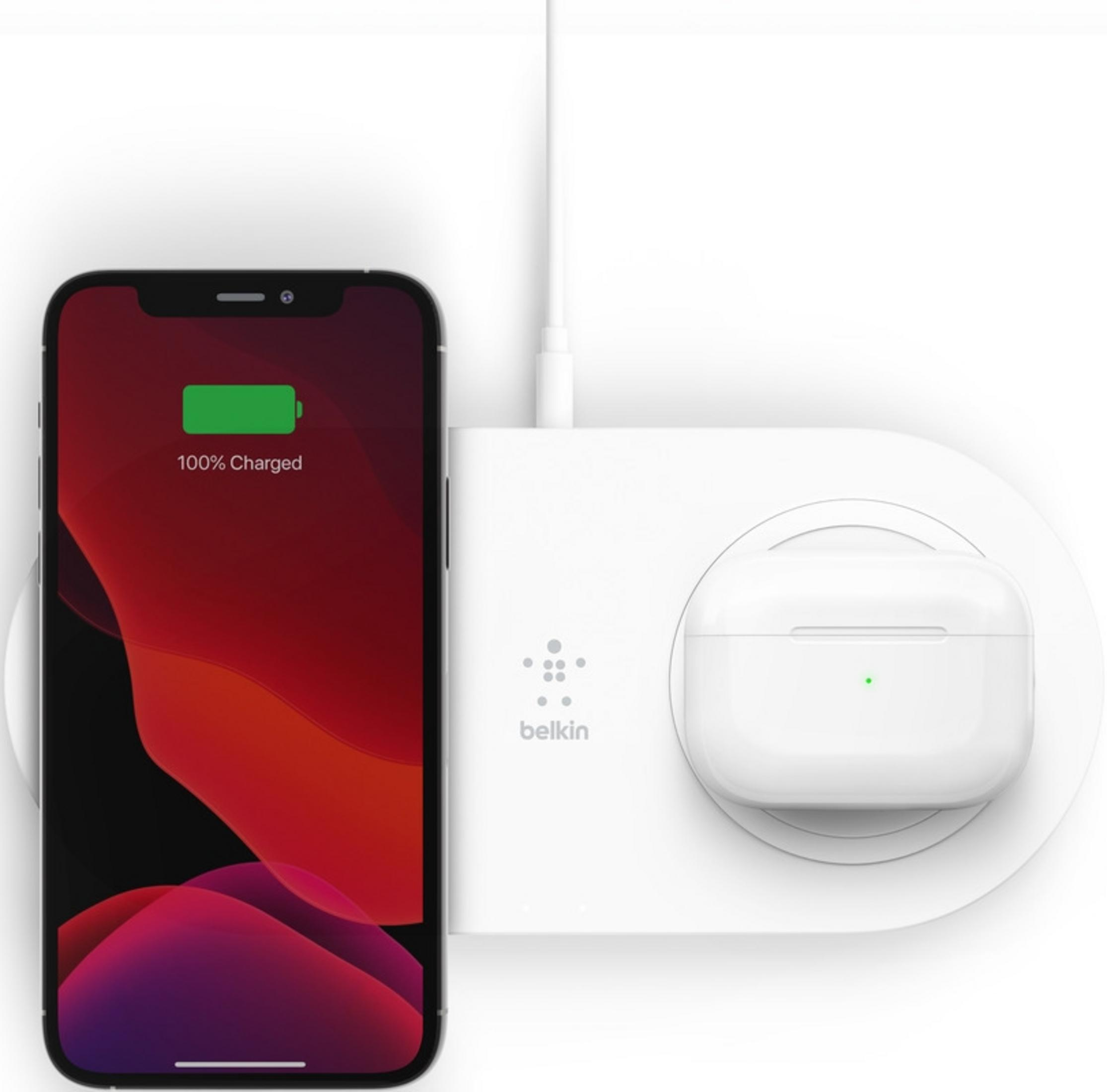 Ein iPhone mit 100% Akku und ein weißes Ladecase auf einem weißen Belkin-Ladegerät.