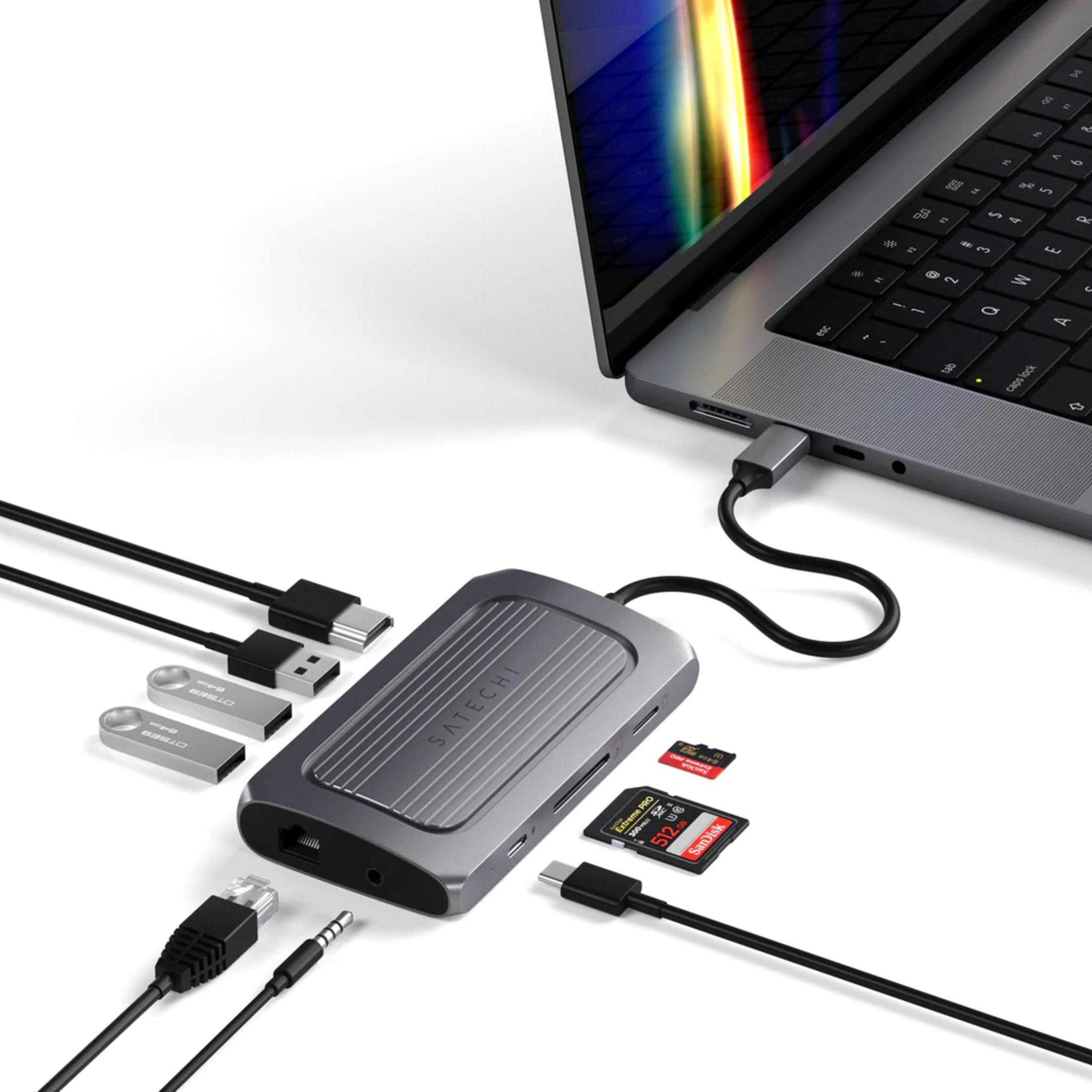 Ein Satechi USB-C-Hub ist mit einem Laptop verbunden, daneben liegen USB-Sticks und Speicherkarten.