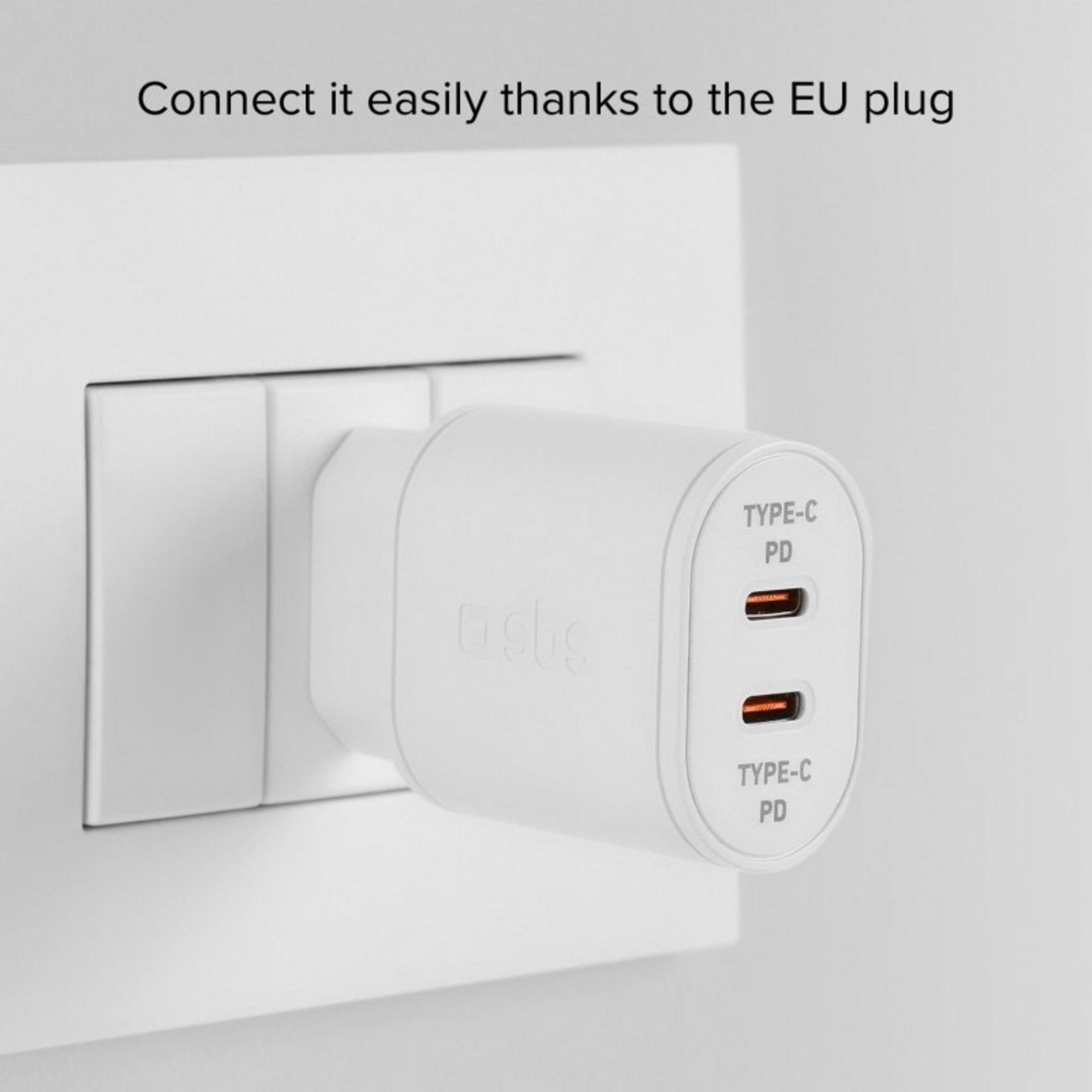 Una spina europea bianca con due porte USB-C 3 inserita in una presa a muro.