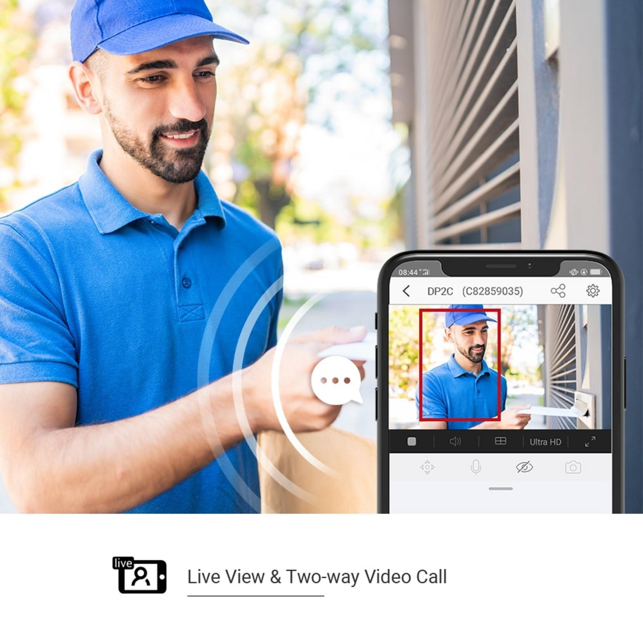 Mężczyzna w niebieskim uniformie dostarcza paczkę. Telefon pokazuje jego obraz.