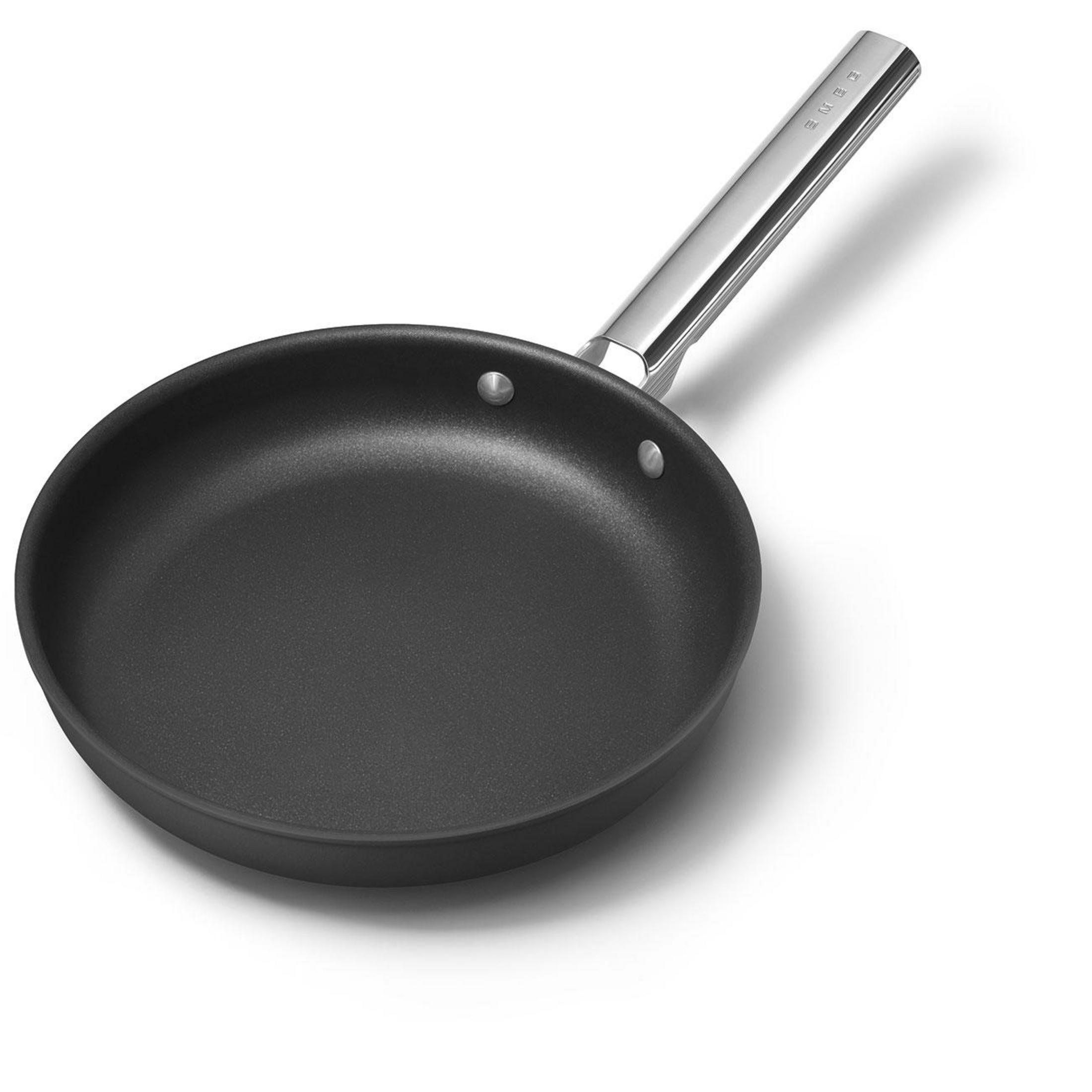 Beyaz arka plan üzerinde parlak metal saplı siyah tava.