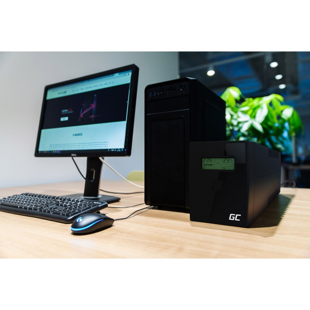 Czarna obudowa komputera, monitor, klawiatura i mysz na drewnianym biurku. Zielony wyświetlacz pokazuje liczby.