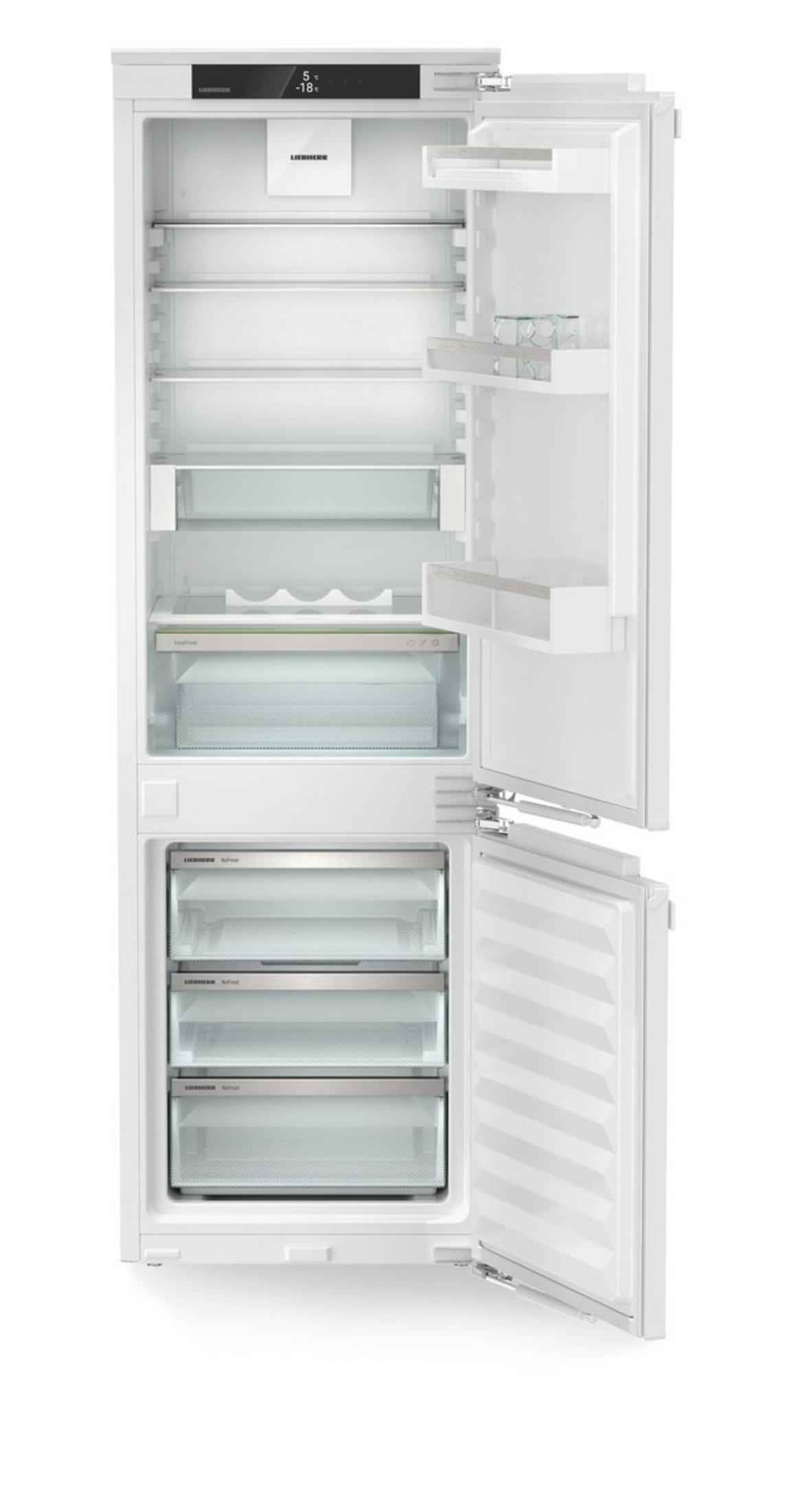 Ein weißer Kühlschrank mit offener Tür, gefüllt mit Regalen und Schubladen.