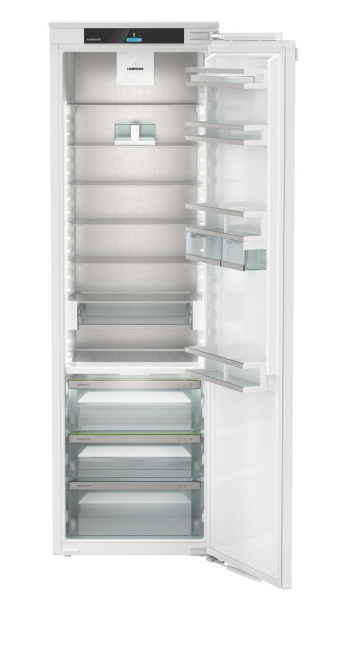 Ein leerer, weißer Kühlschrank mit offener Tür, silbernen Regalen und Schubladen.