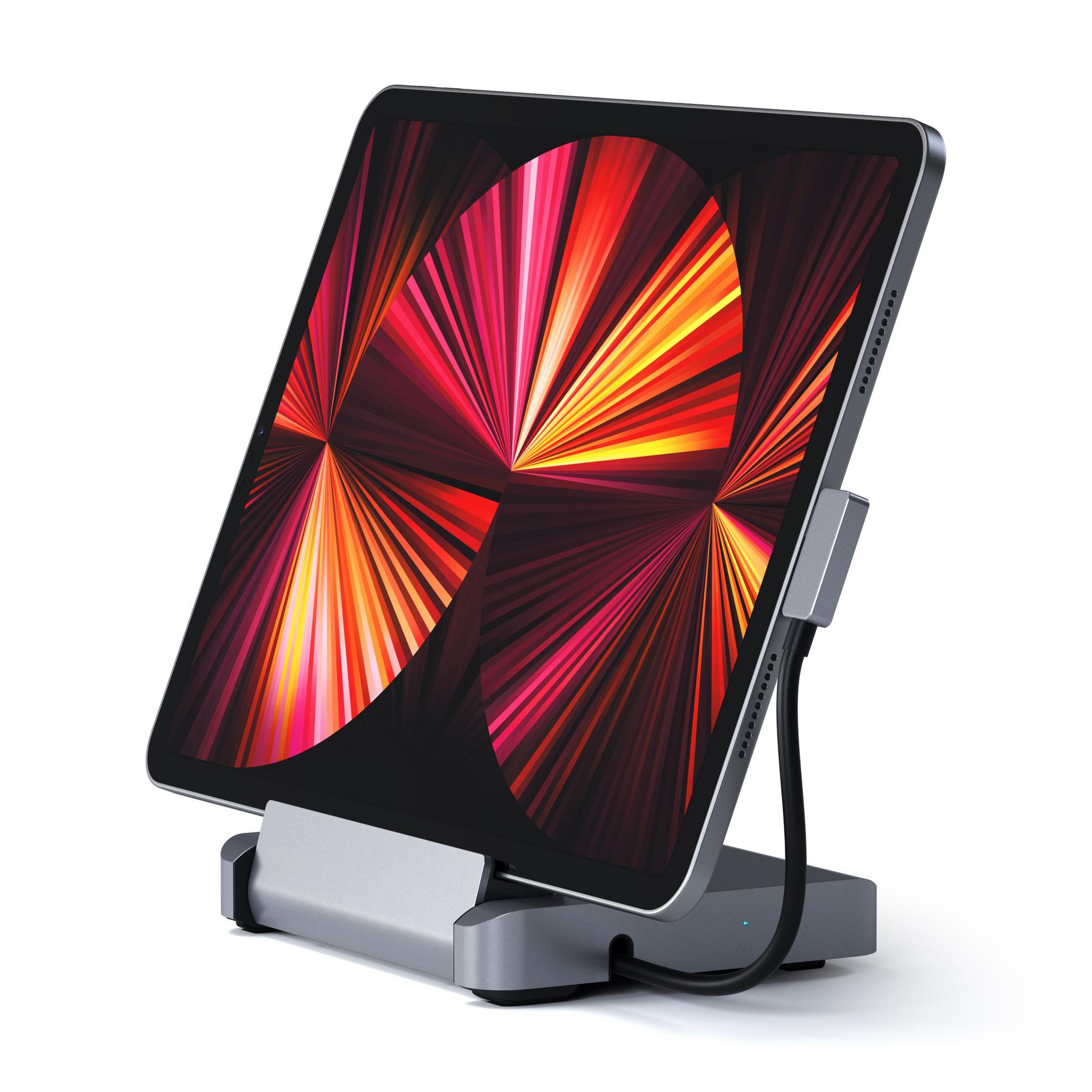 Graues Tablet auf einem Ständer mit abstraktem Hintergrund. Ein Kabel ist angeschlossen.