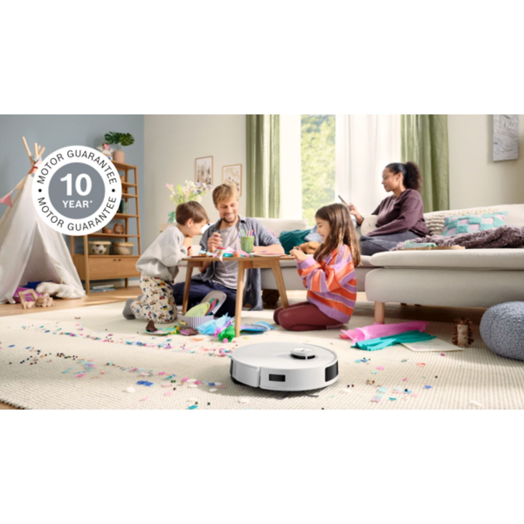 Ein Roboterstaubsauger reinigt einen Teppich, auf dem Kinder spielen.