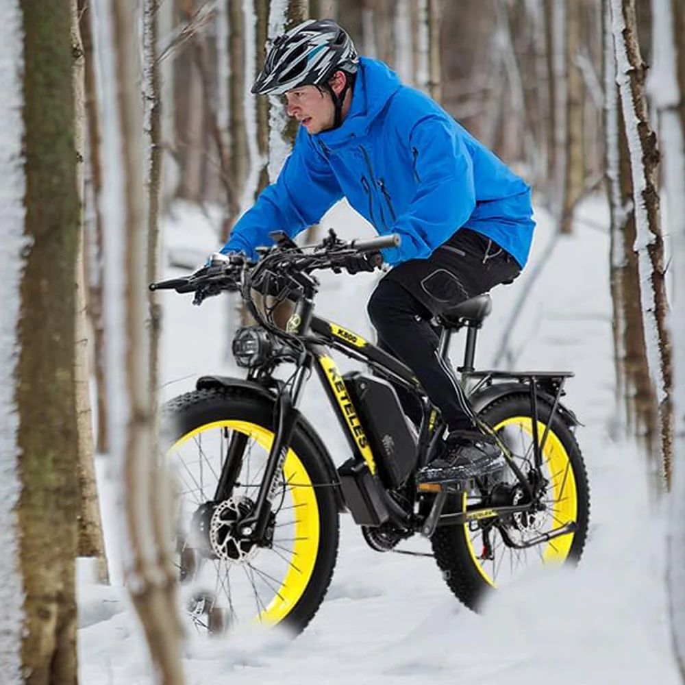Un hombre monta una e-bike de ruedas anchas por un bosque nevado.