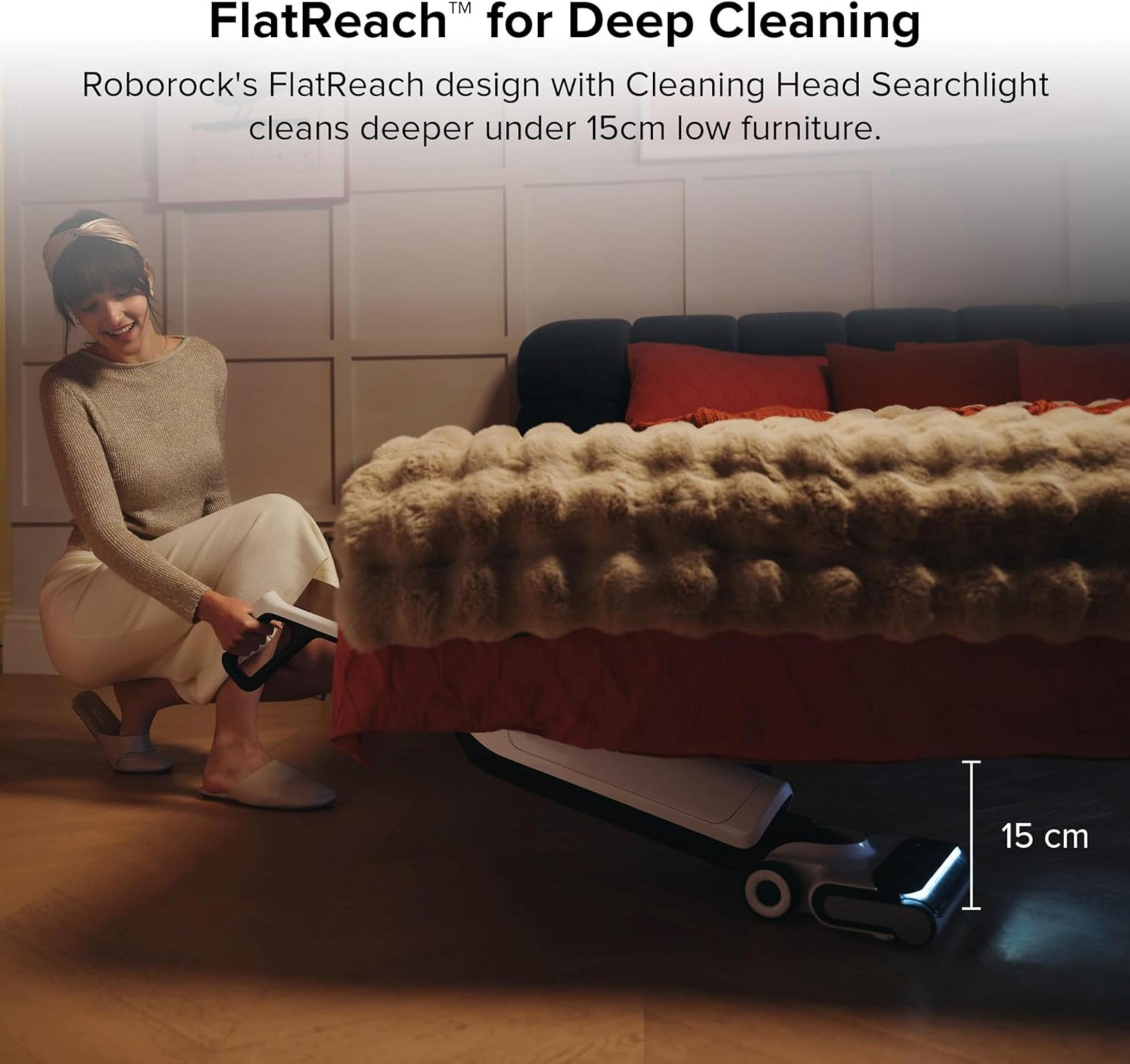 Une femme nettoie sous un lit avec un aspirateur à tête plate.