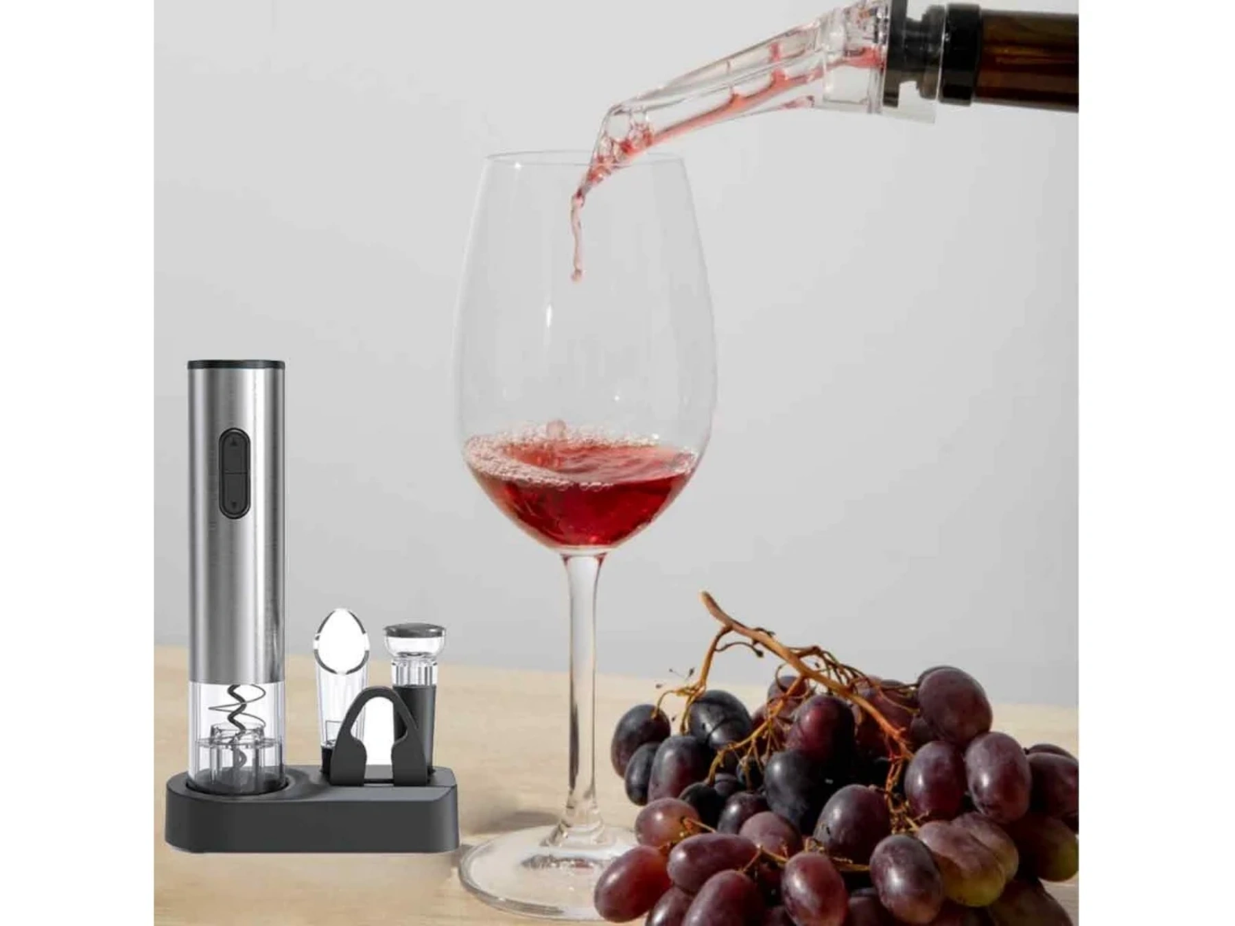 Ein elektrischer Weinkorkenzieher mit Zubehör, Wein wird in ein Glas gegossen.
