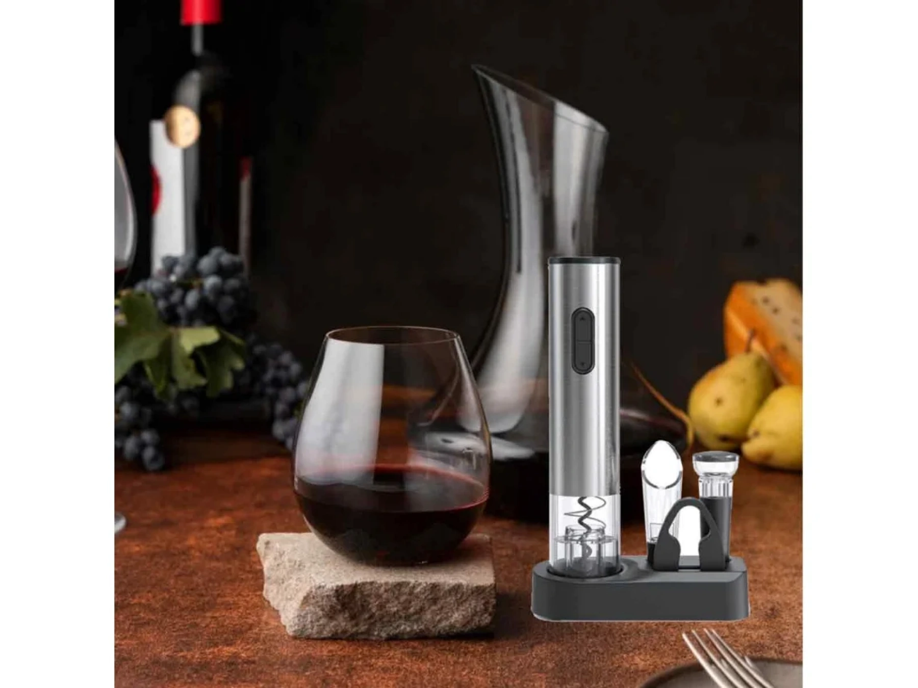 Ein Wein-Set mit elektrischem Korkenzieher, Dekanter, Weinglas und Trauben.