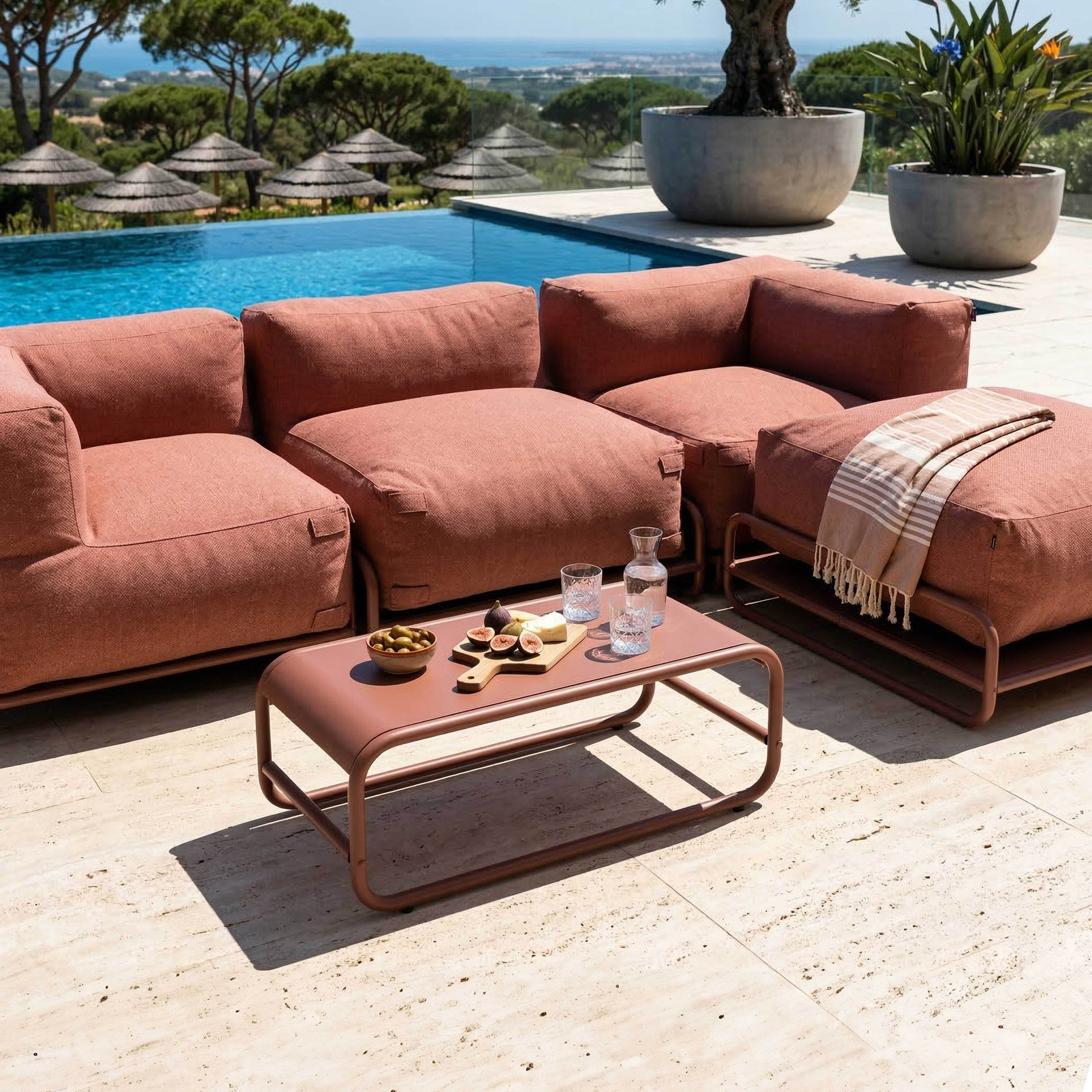 Rote Lounge-Möbel am Pool mit Blick auf das Meer, serviert mit Feigen und Oliven.