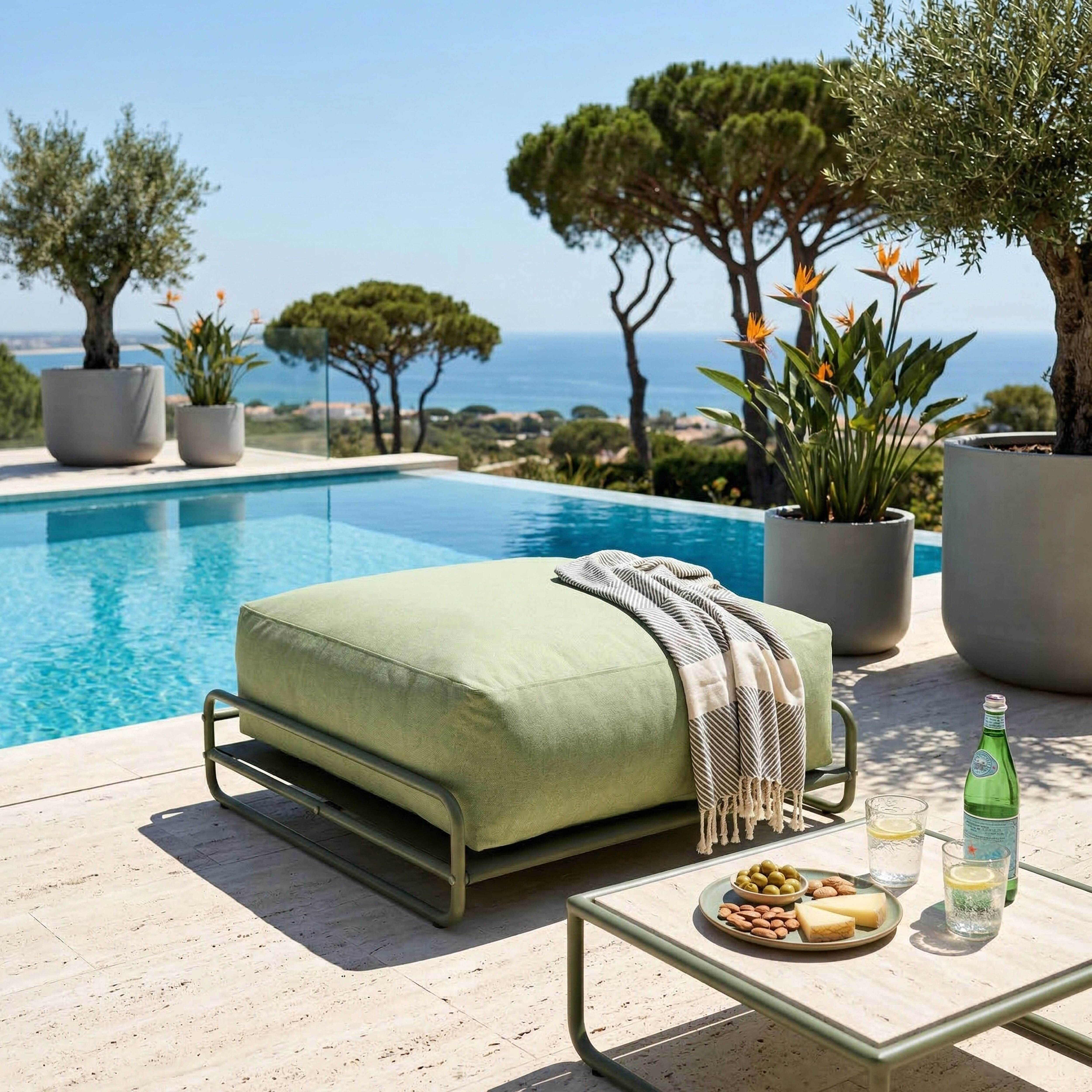Grünes Outdoor-Sitzkissen am Pool mit Snacks und Getränken.