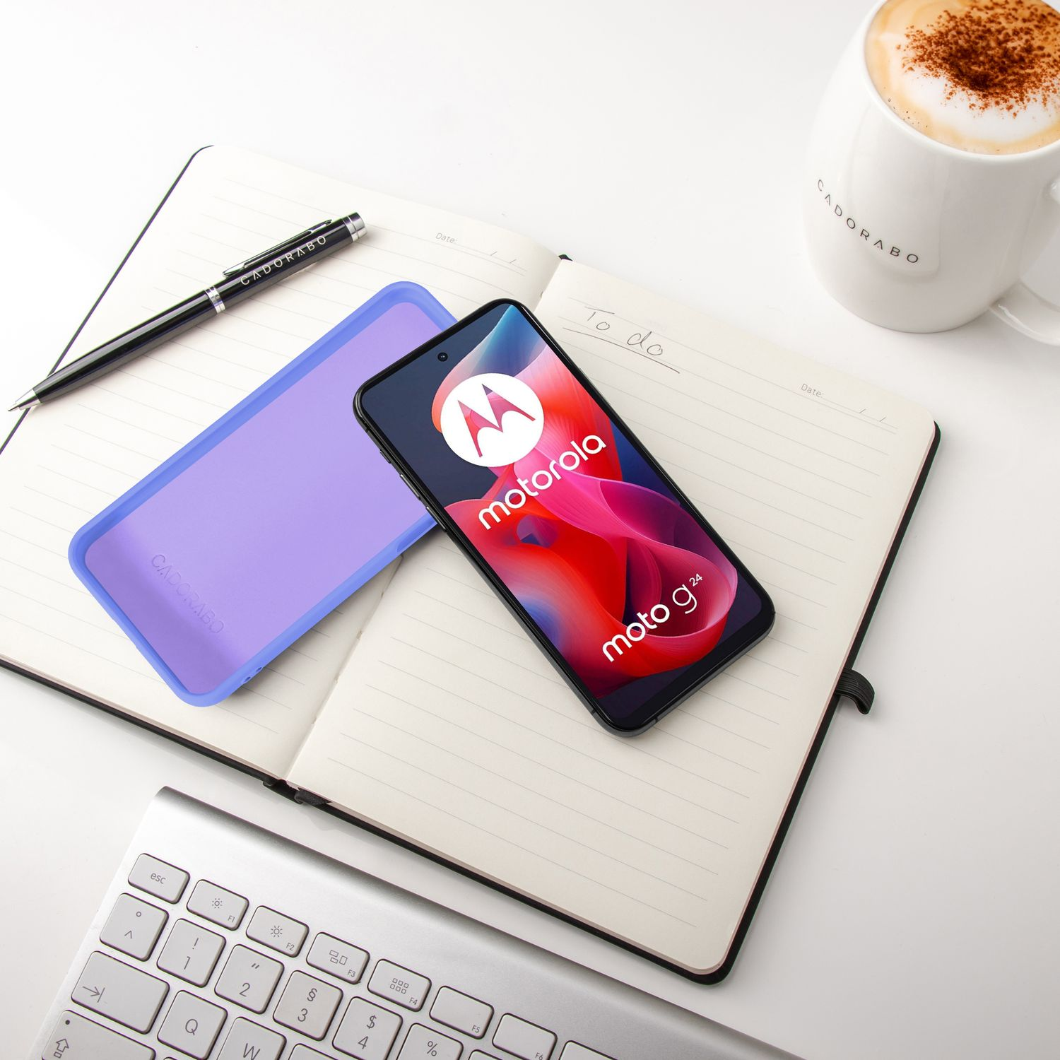 Ein Motorola-Telefon liegt auf einem Notizbuch neben einer Kaffeetasse.