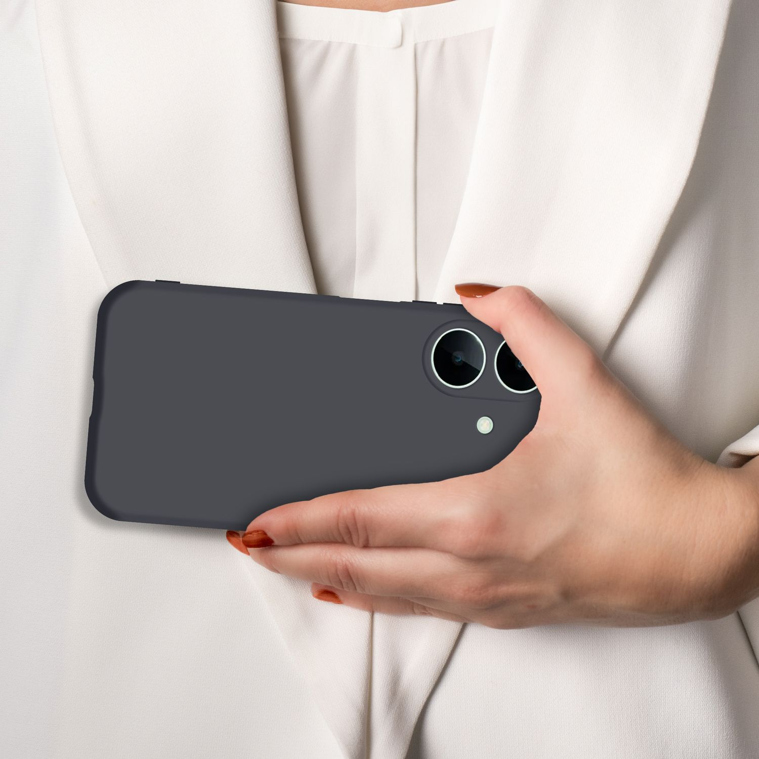 Eine Hand hält ein dunkles Smartphone vor einer weißen Bluse.