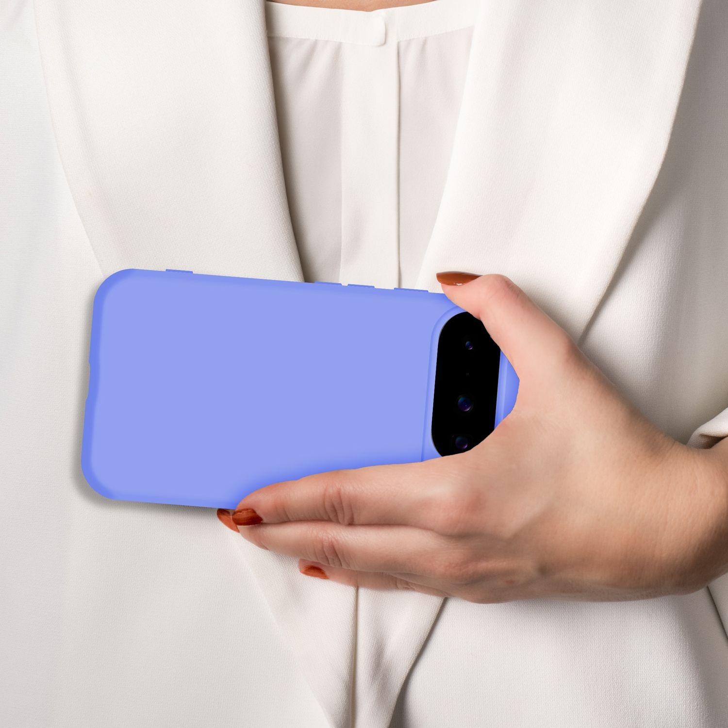 Eine Hand hält ein lila Handy vor einem weißen Hemd.