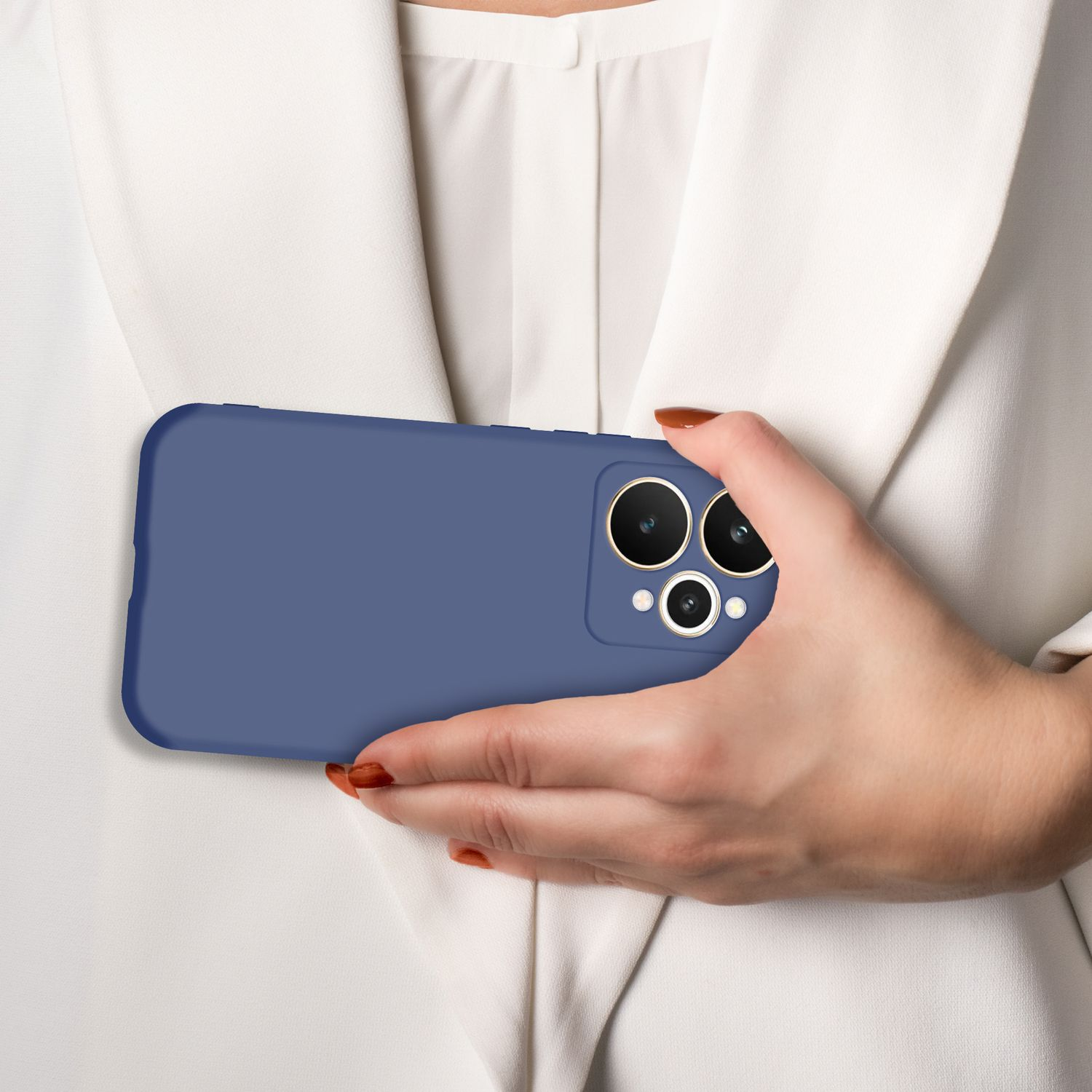 Eine Hand mit blauen Nägeln hält ein blaues Handy vor einem weißen Hemd.