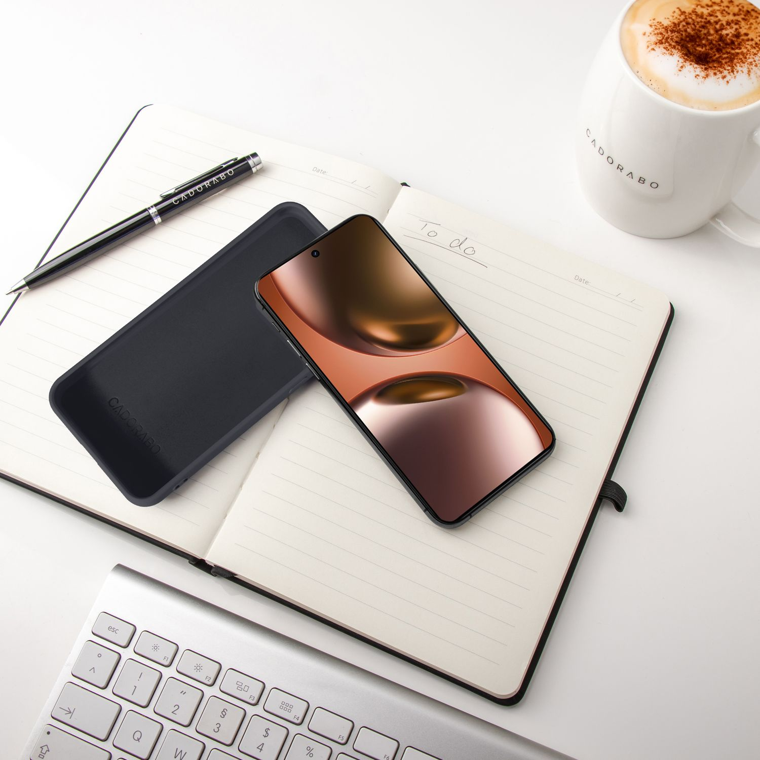 Ein offenes Notizbuch mit Stift, Handy, Hülle und Kaffee.