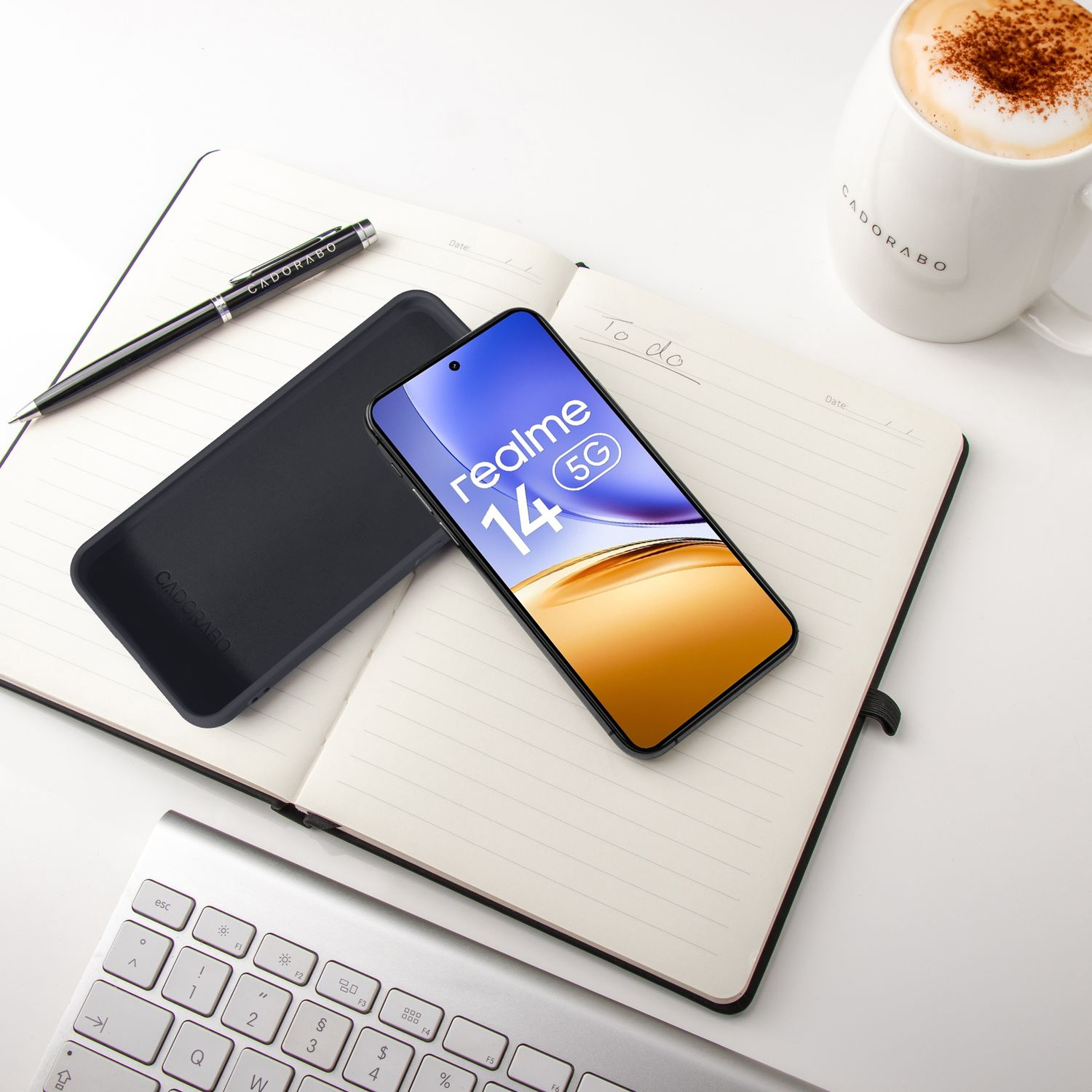 Ein Smartphone liegt auf einem Notizbuch neben einem Stift und einer Kaffeetasse.