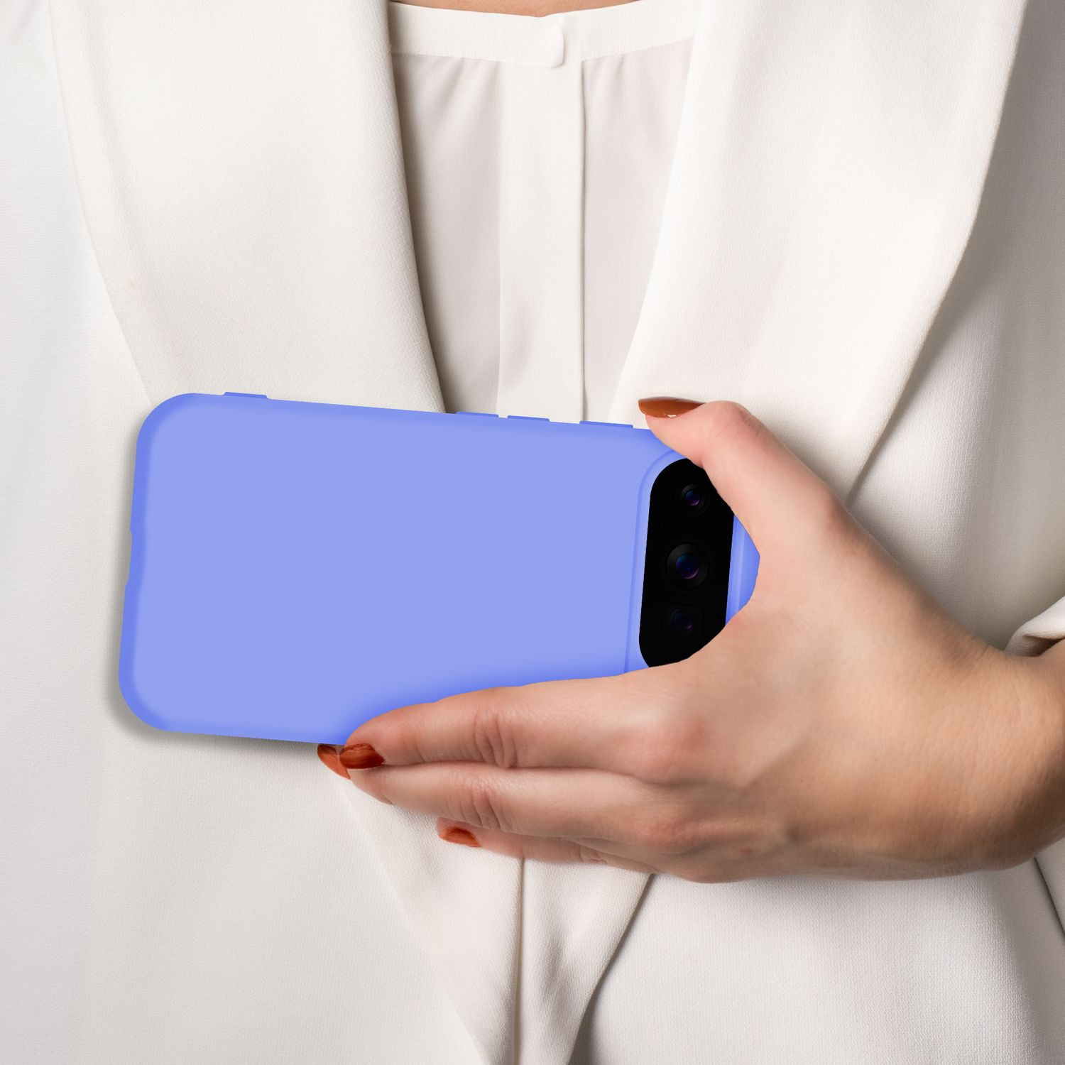 Eine Hand hält ein lila Smartphone vor einem weißen Blazer.