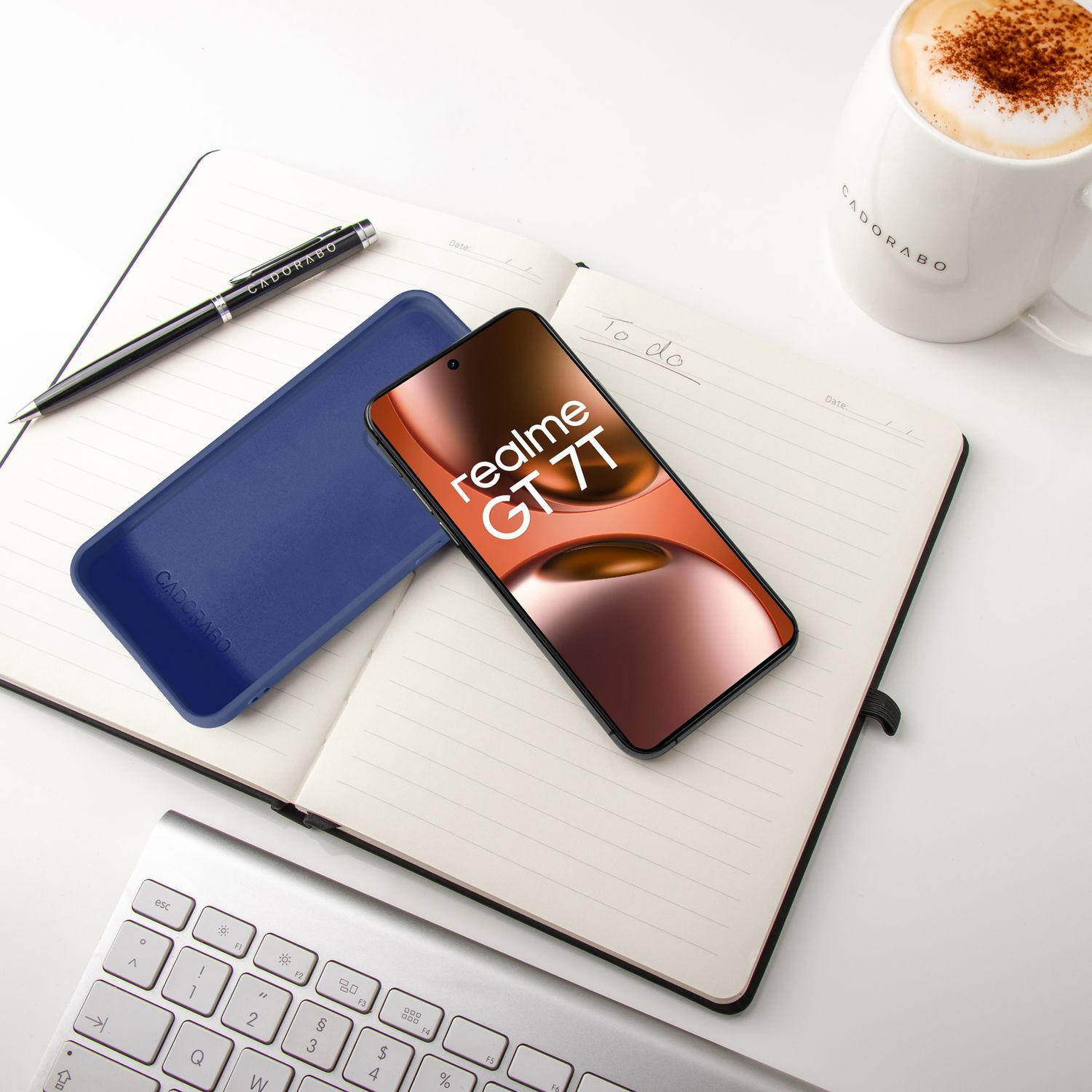 Ein Smartphone liegt auf einem Notizbuch neben einer Kaffeetasse.