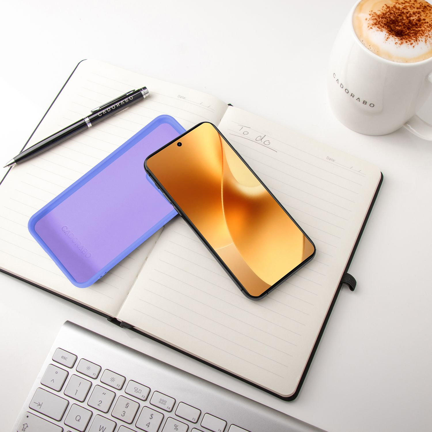 Ein Smartphone, ein Notizbuch, eine Tasse Kaffee und eine Tastatur auf weißem Hintergrund.