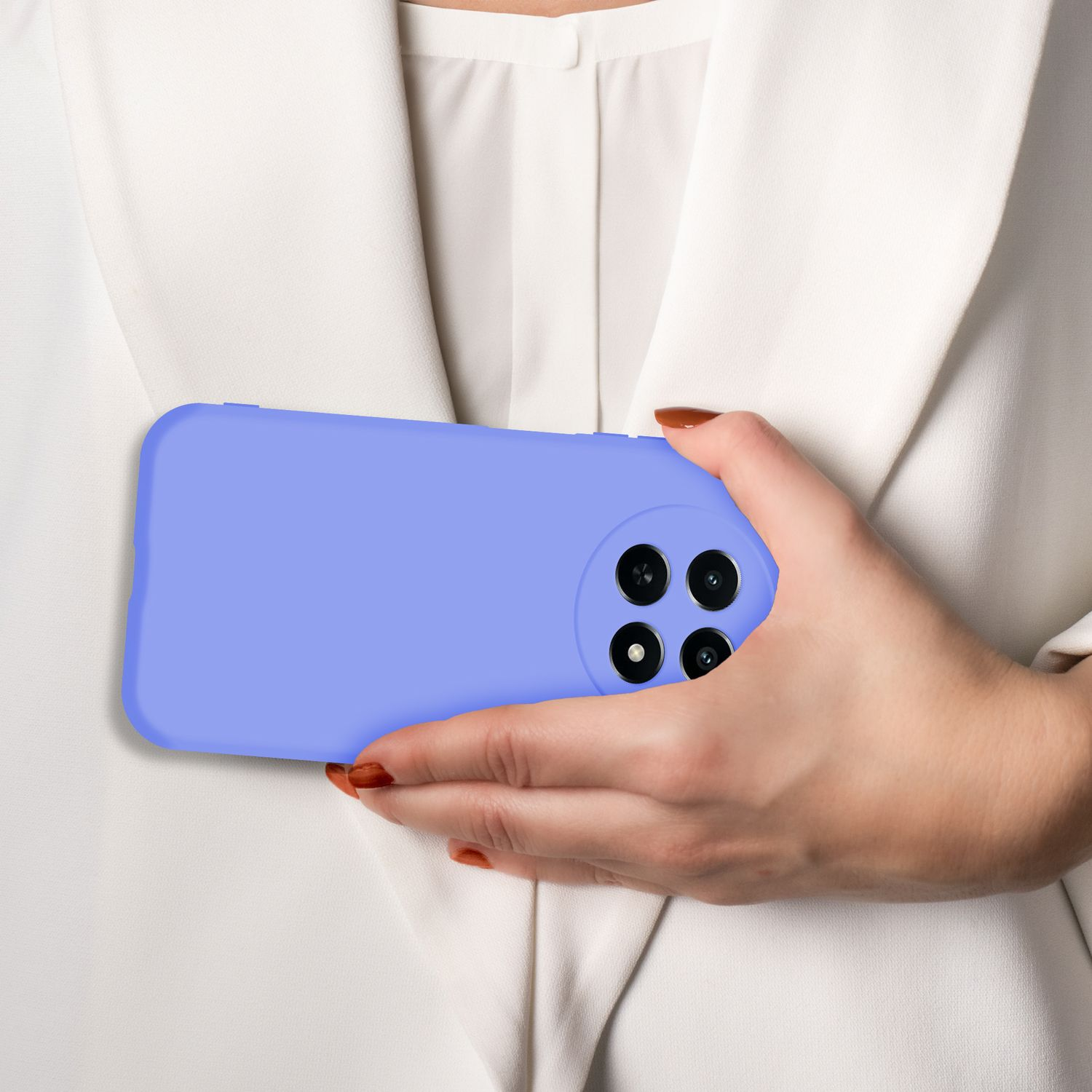 Eine Hand hält ein lila Handy mit vier Kameras vor einem weißen Blazer.