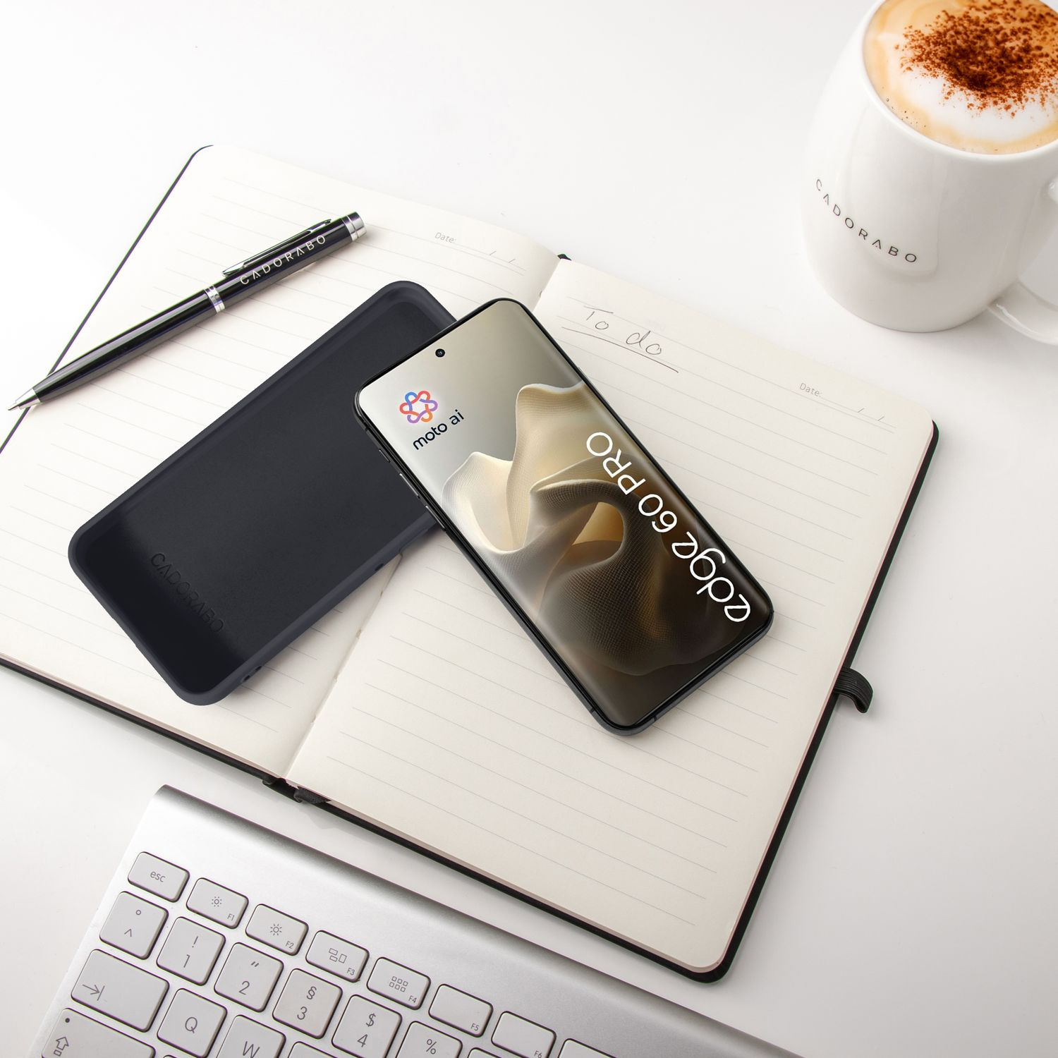 Ein Smartphone liegt auf einem Notizbuch neben einer Kaffeetasse.