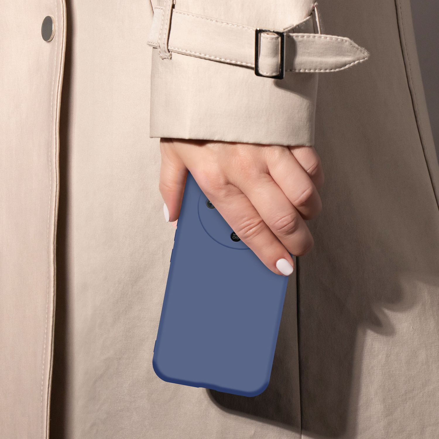 Eine Hand hält ein blaues Smartphone vor einem beigen Trenchcoat.