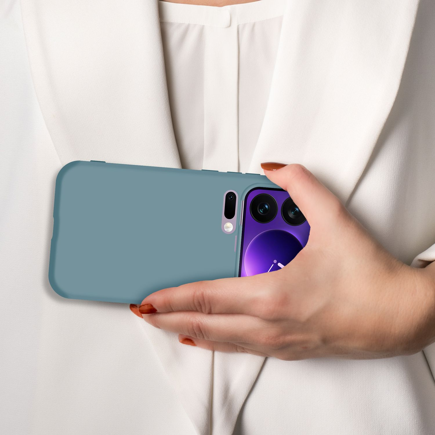 Eine Hand hält ein blaues Handy mit Kameramodul vor einem weißen Hemd.