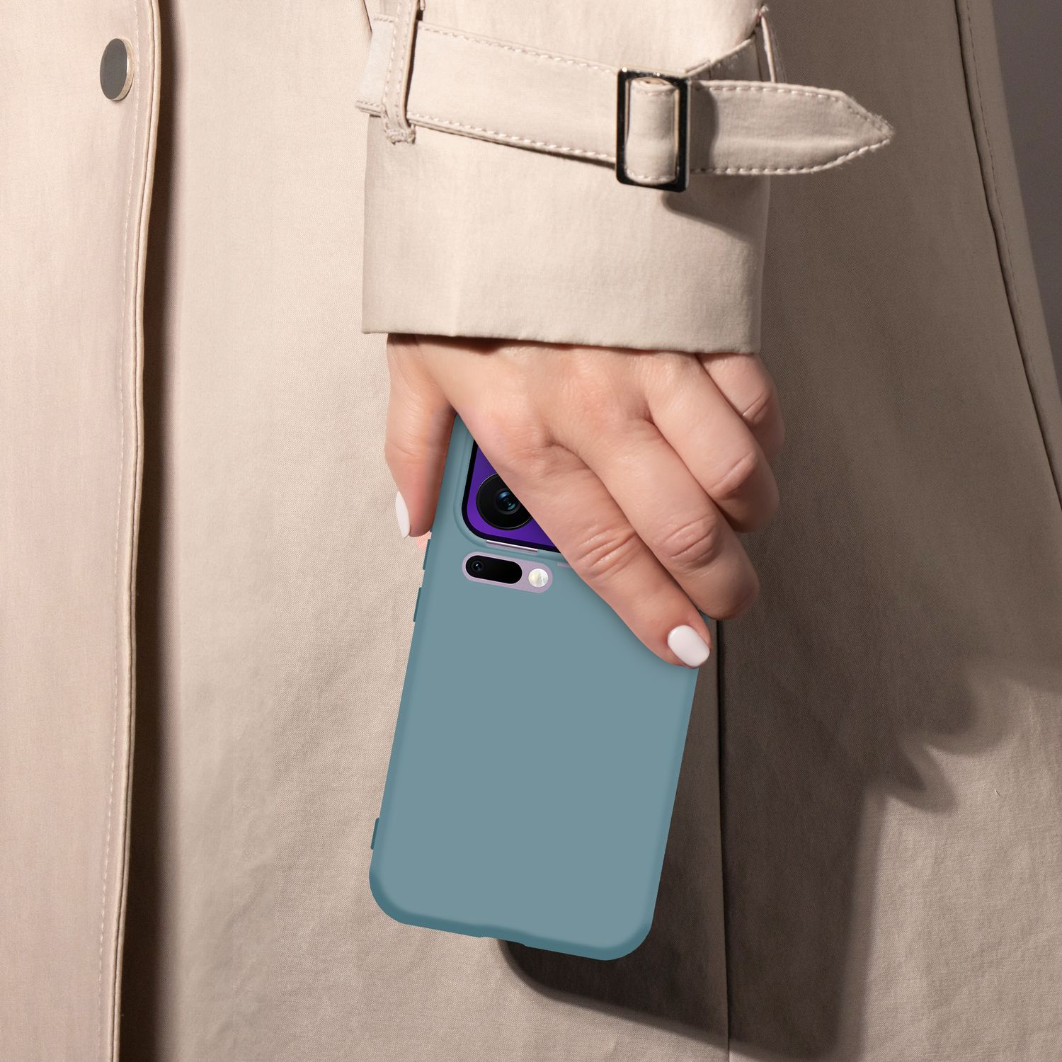 Eine Hand hält ein blaues Handy vor einem beigen Trenchcoat.