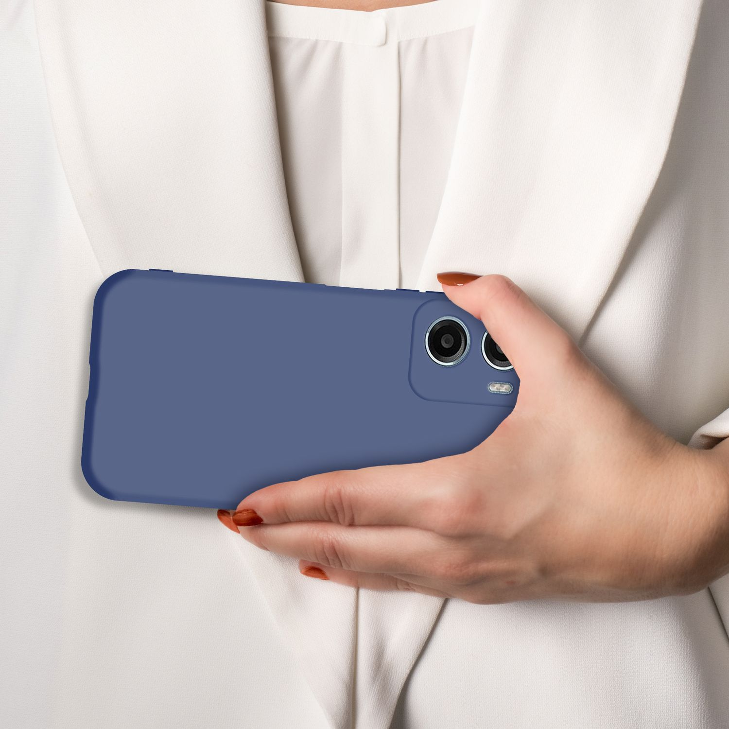 Eine Hand hält ein blaues Smartphone vor einem weißen Hemd.