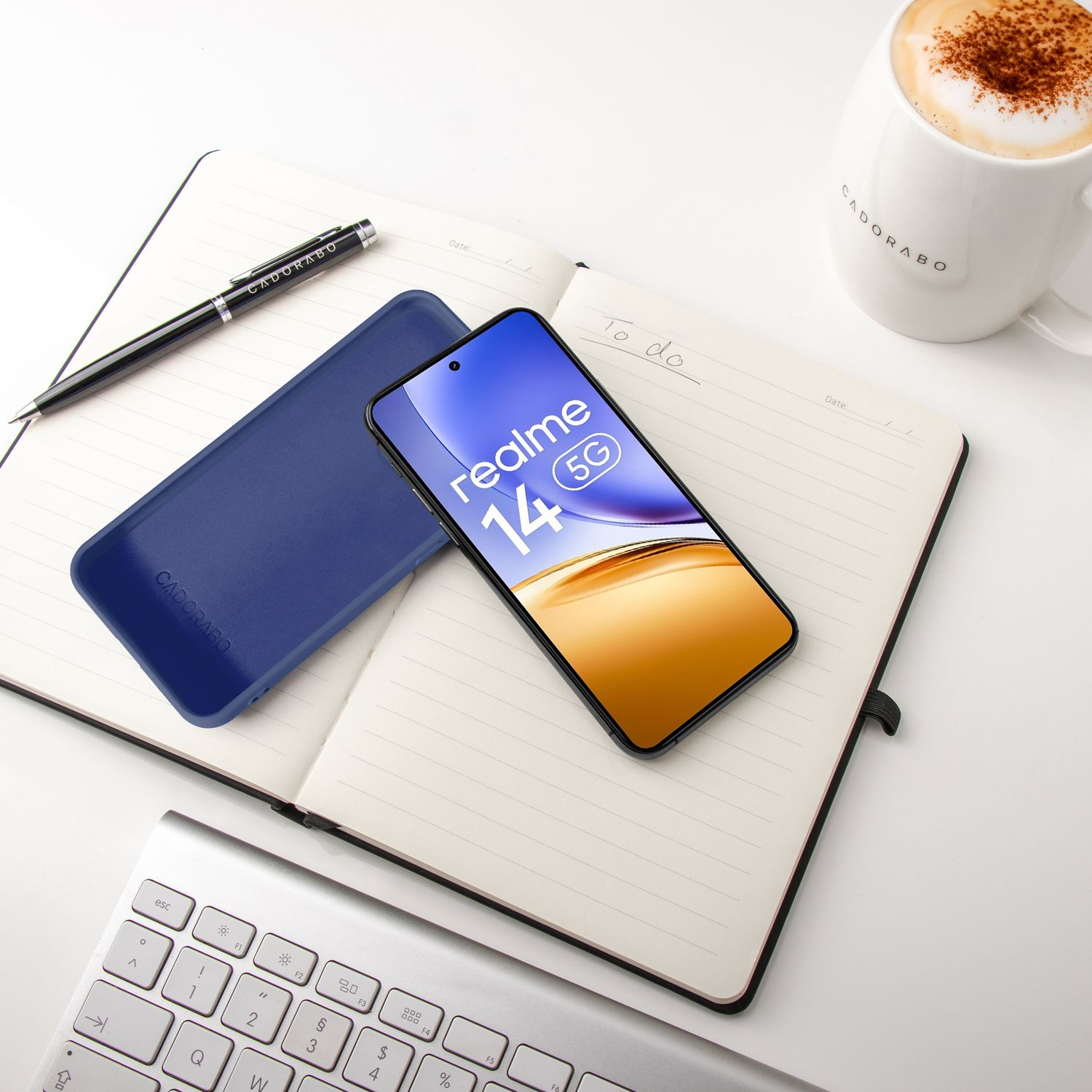 Ein Smartphone, Hülle, Notizbuch, Stift, Tastatur und Kaffee auf weißem Hintergrund.