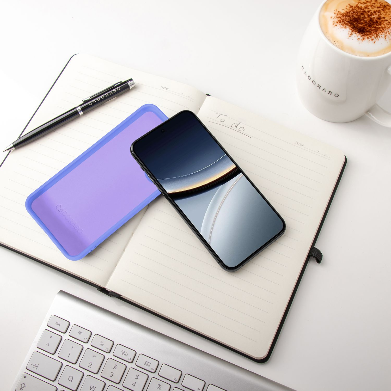 Ein offenes Notizbuch mit Stift, Handy, Hülle und Kaffee.