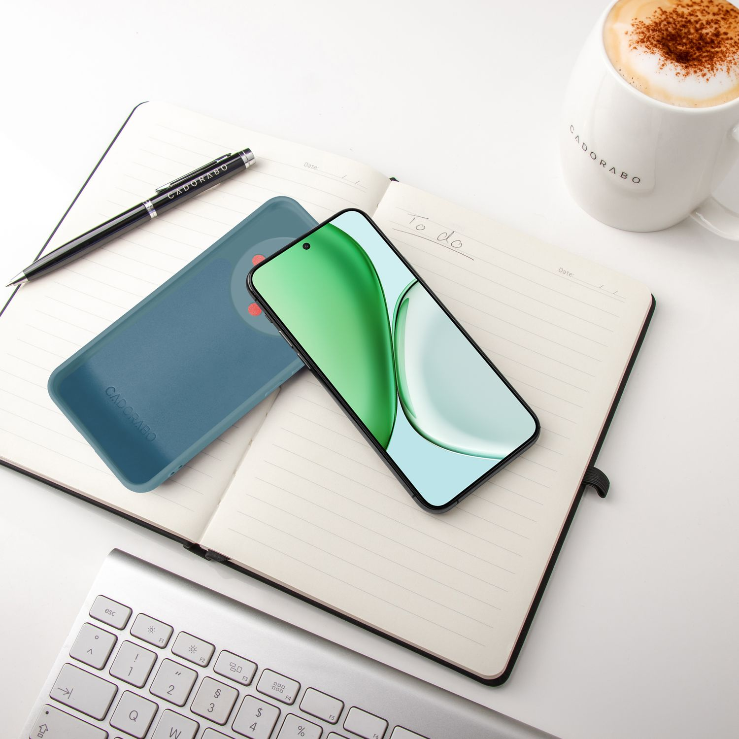 Ein Smartphone, Notizbuch, Stift, Tastatur und eine Kaffeetasse auf weißem Hintergrund.