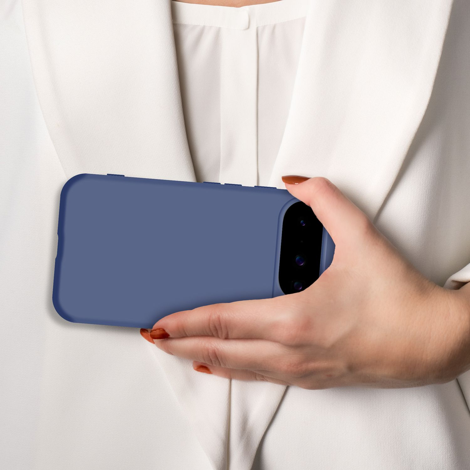 Eine Hand hält ein blaues Smartphone vor einem weißen Hemd.
